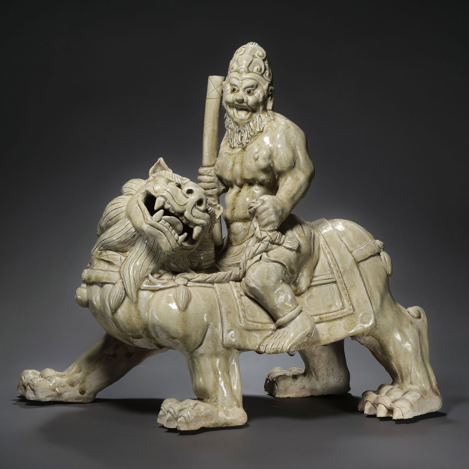 Chinese Sui Dynasty Xiangzhou Kiln Celadon Figurine of a Foreigner Riding a Lion: H. 49 cm. W. 42 cm.