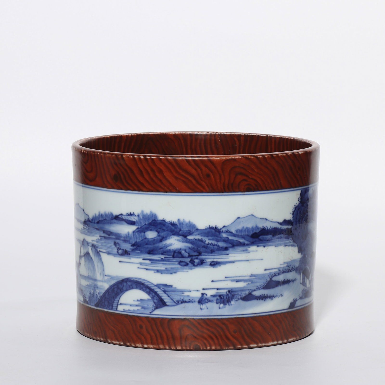 A wood-grained blue-and-white porcelain brush pot with landscape and figure motifs from the: H. 14 cm. Diam. 18 cm.