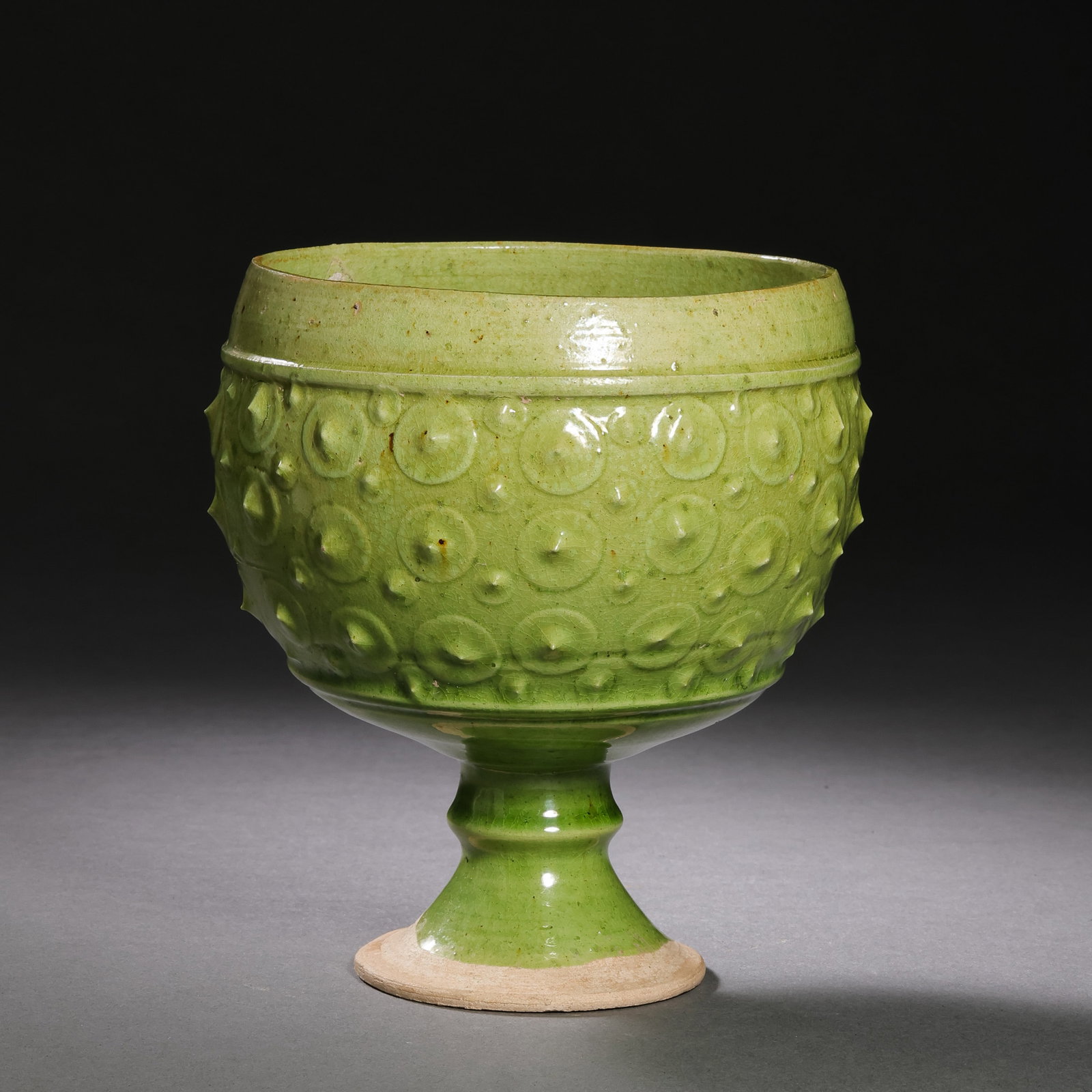 Chinese Sui Dynasty Green-glazed Drum-nail Pattern Stem Cup: H. 12 cm. Diam. 9.3 cm.