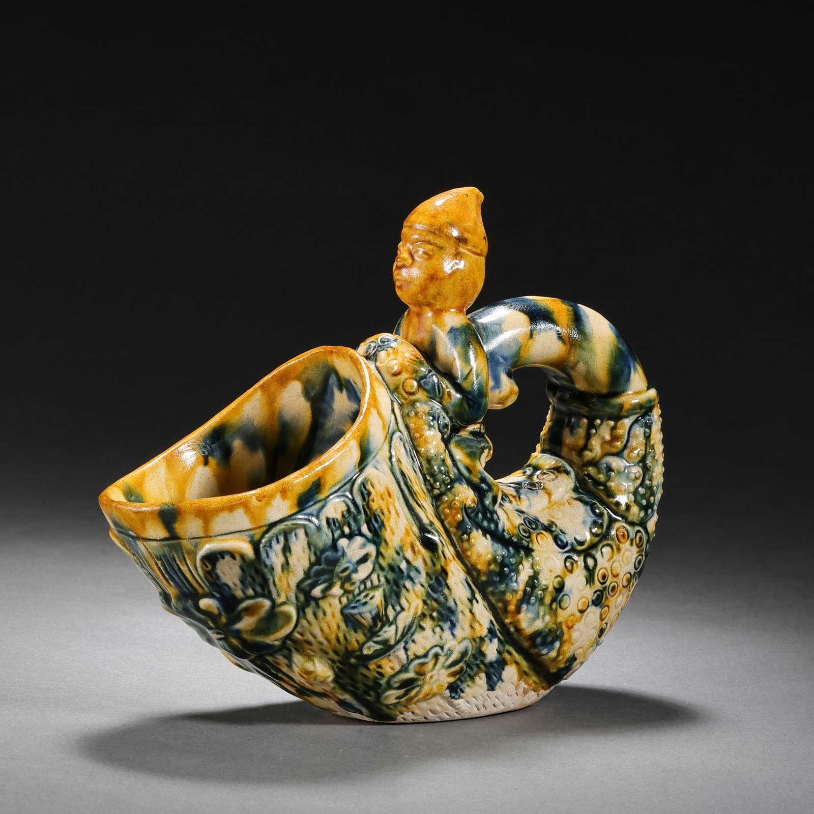 Chinese Tang Dynasty Sancai (three-color glazed) figure-shaped wine cup: H. 13.3 cm. L. 16.8 cm.