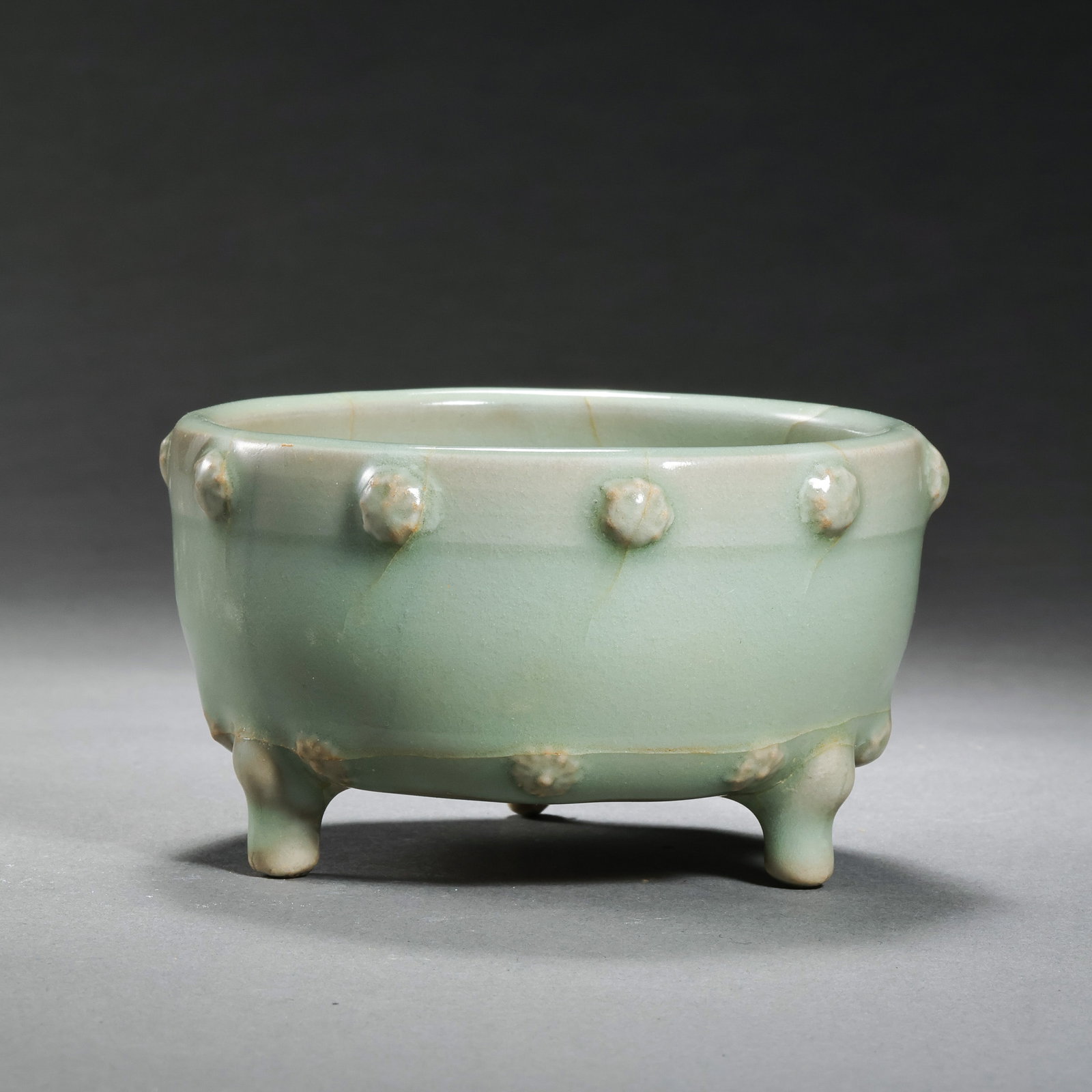 A celadon tripod censer with drum-nail pattern from the Longquan kiln of the Southern Song Dynasty,: H. 5 cm. Diam. 8 cm.