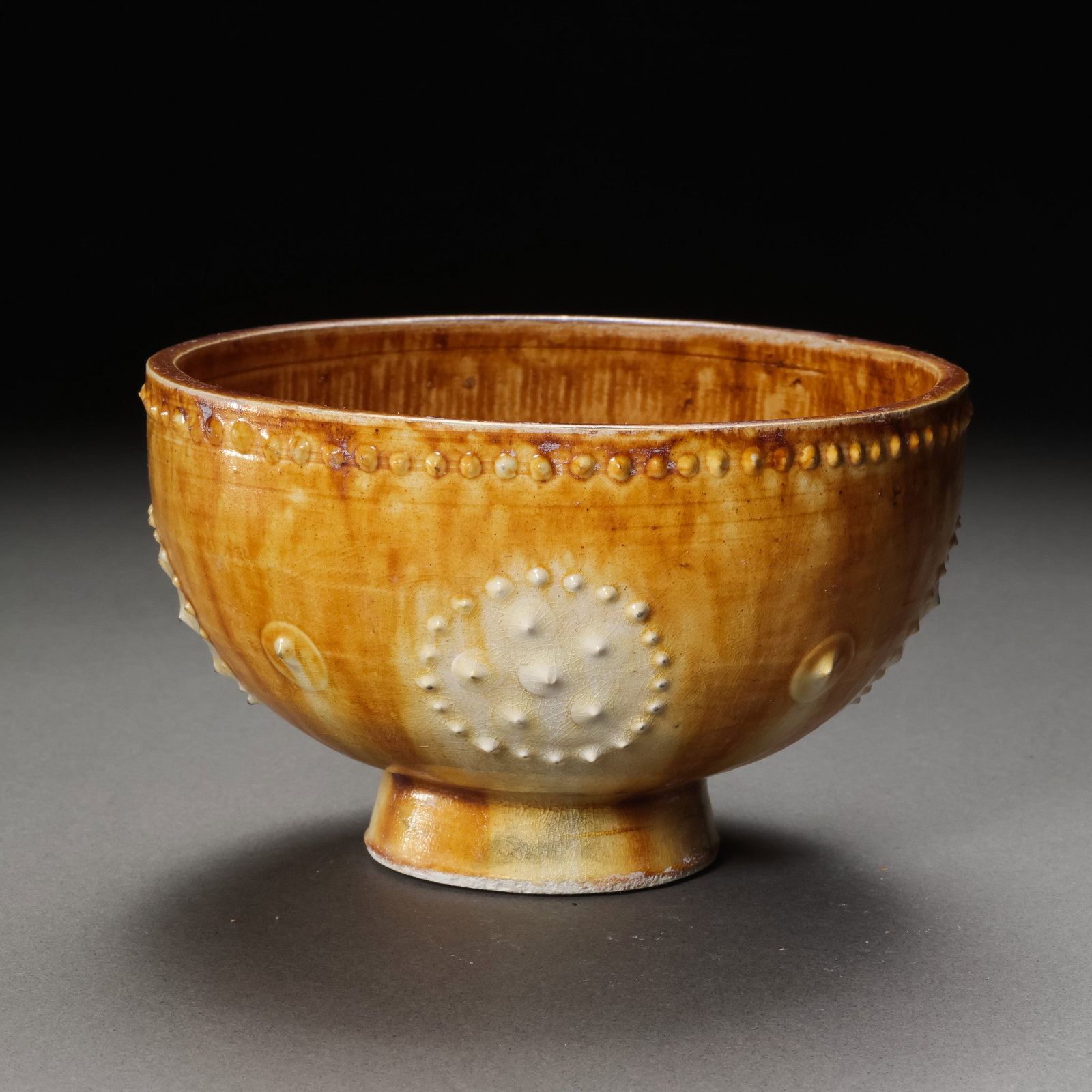 Yellow-glazed cup with drum-nail pattern from the Sui Dynasty of China: H. 6 cm. Diam. 9.5 cm.