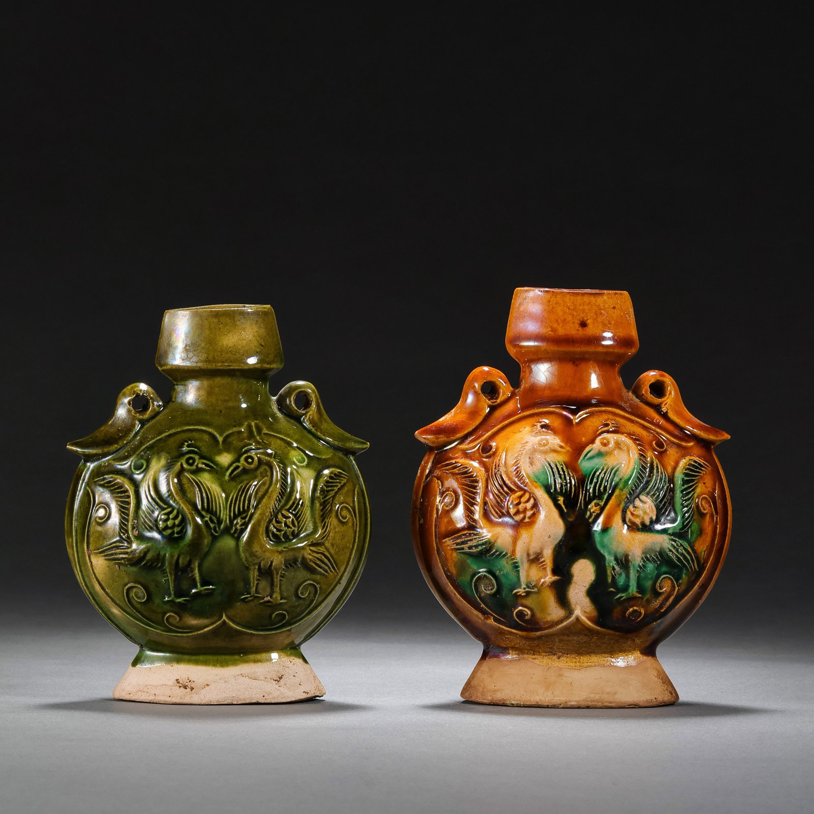A pair of Chinese Tang Dynasty sancai (three-color glazed) double phoenix flat bottles: H. 10.3 cm. W. 8.5 cm.
