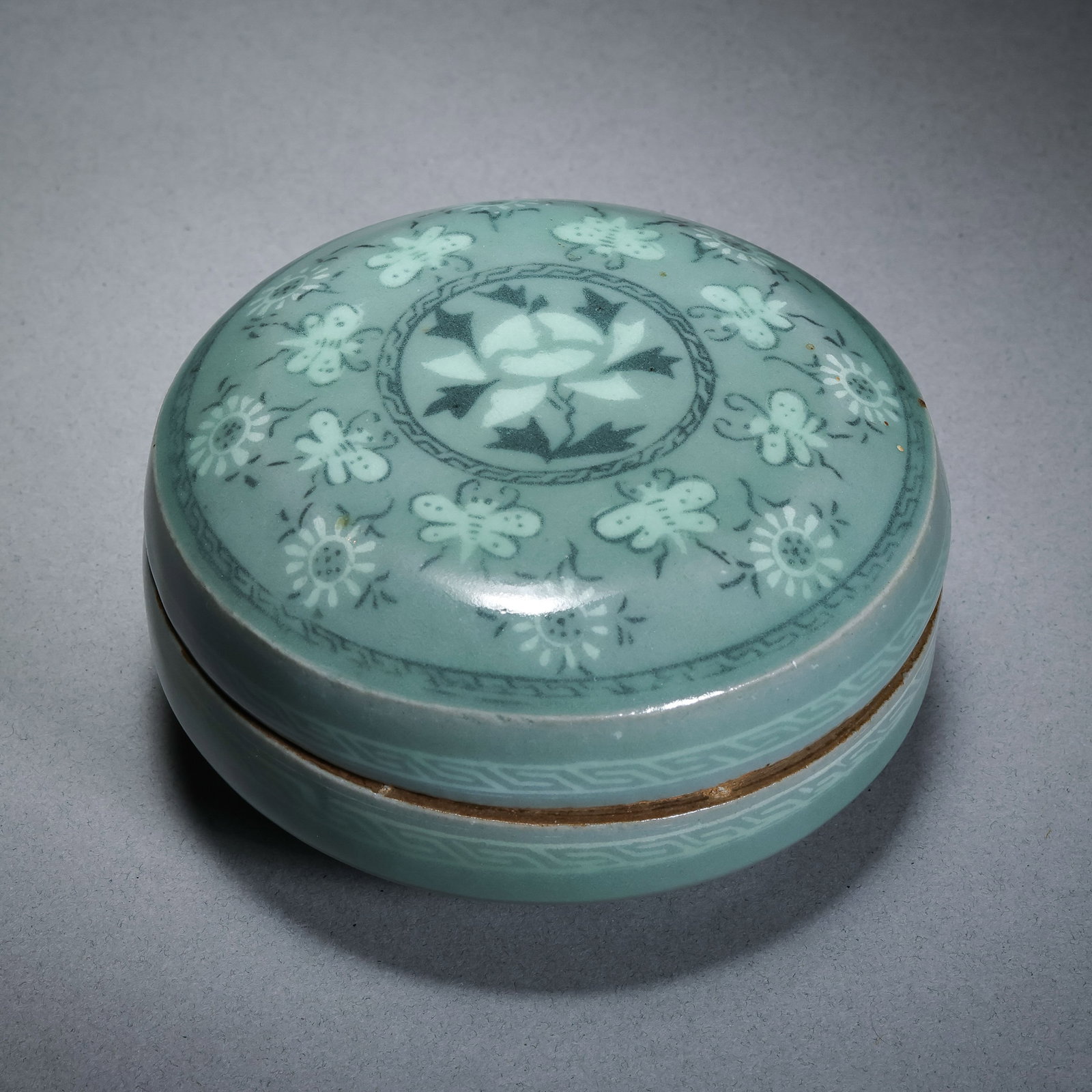 Korean Goryeo celadon black and white inlaid flower and butterfly pattern lidded box: Diam. 8.5 cm. H. 5 cm.