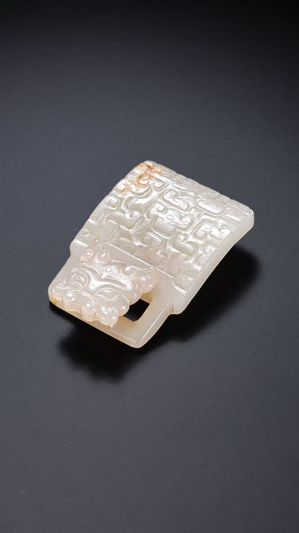 White jade belt buckle with animal mask design from the Warring States period of China: L. 5 cm. W. 3.4 cm. Weight. 27 gram.