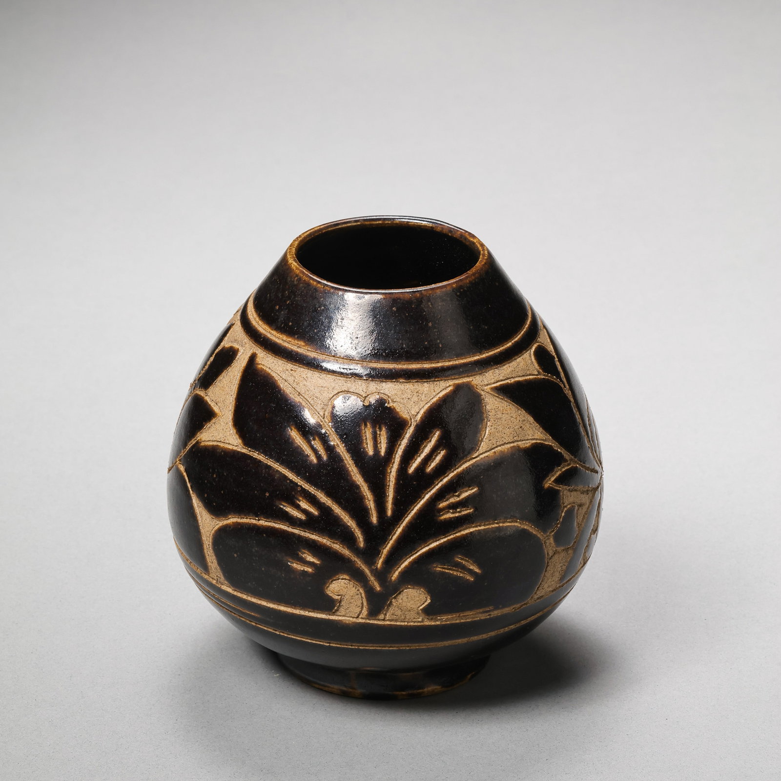 Northern Song Dynasty Cizhou Kiln Black Glazed Chicken Heart-Shaped Jar with Carved Floral Pattern: H. 10.7 cm.