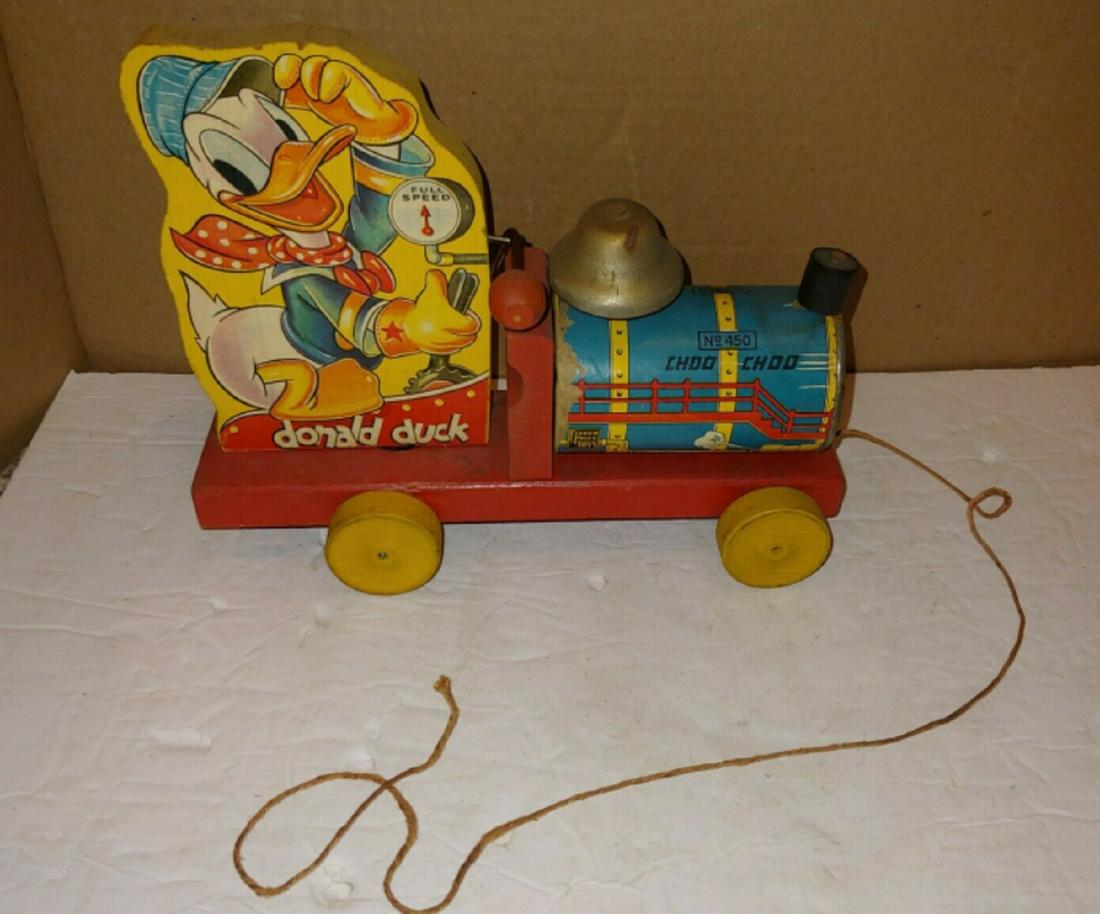 Fisher Price Walt Disney No. 450 Donald Duck Choo Choo 1940: 1940's wood and metal Fisher Price train engine locomotive loco pull toy - "Donald Duck, Choo Choo, No. 450, Fisher Price Toys, Created At East Aurora, N.Y., Pat. No. 2,069,181, Made In U. S. A.". The