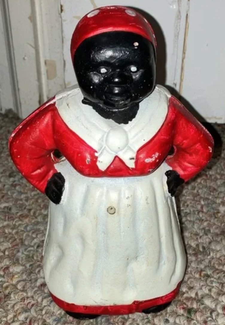 Black Americana Cast Iron Bank Aunt Jemima Figurine: Black Americana Cast Iron Bank Aunt Jemima Figurine. Early 1900s molded cast iron in the shape of a mammy figurine. Has slot in back for holding change and the screw had to be replaced as it was rusty