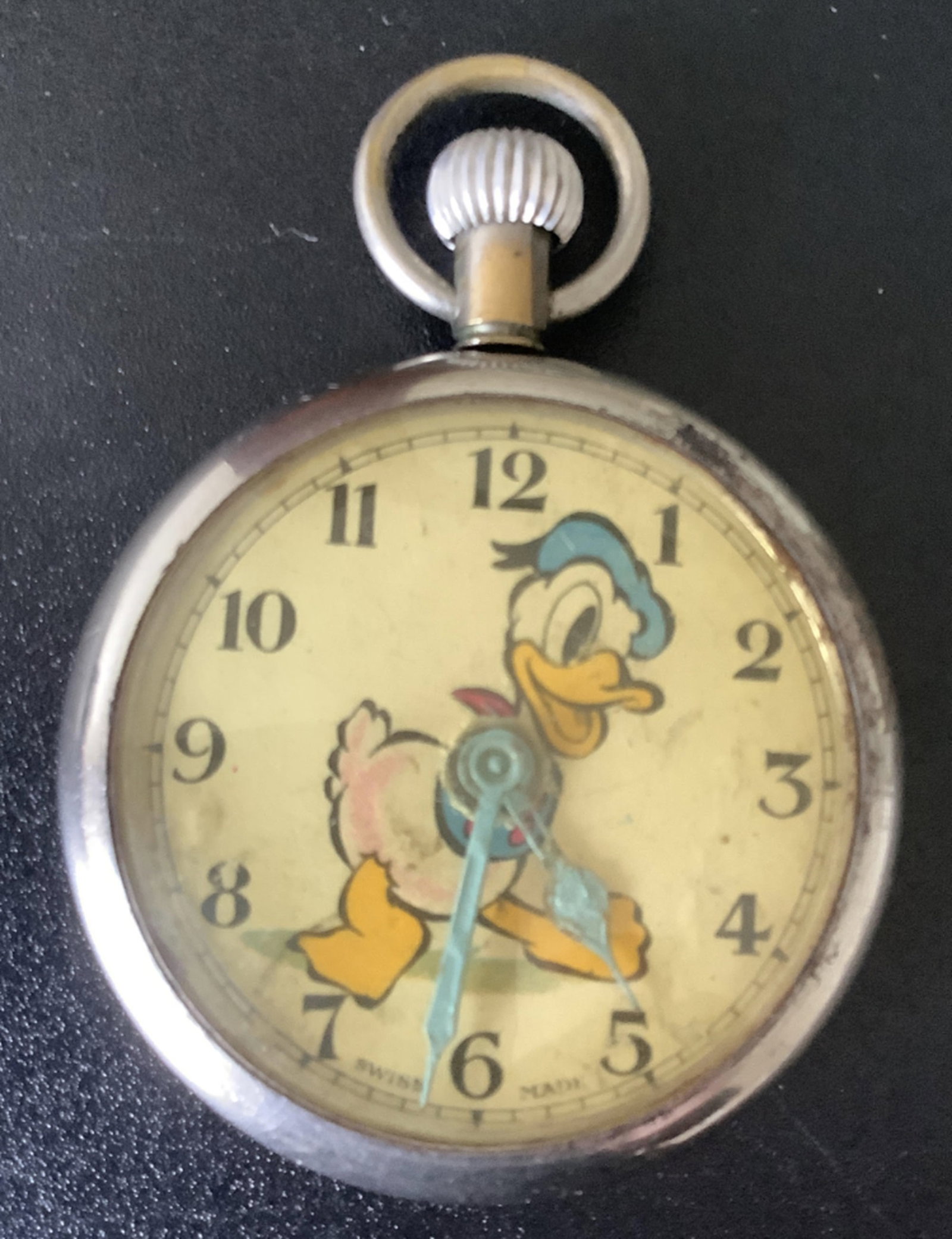 Antique Disney Donald Duck Swiss Made Long Stem Pocket Watch: Antique Disney Donald Duck Swiss Made Long Stem Pocket Watch. The watch does run when wound for various amounts of time. The round silver metal case has surface wear and scratches. 12 hour number dial