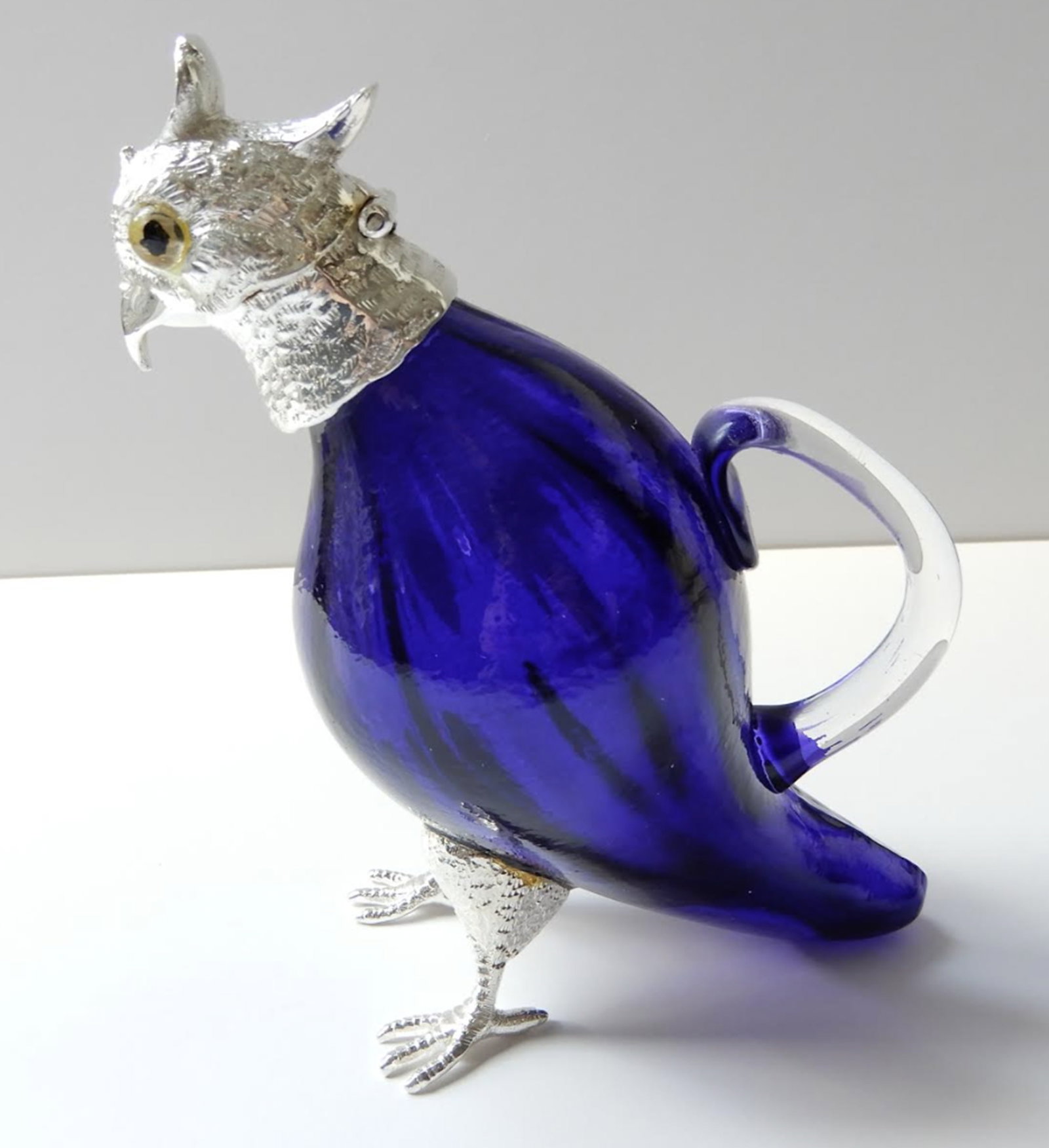 Victorian style French Blue Parakeet Jug Decanter.: Victorian style French Blue Parakeet Jug Decanter. The glass body of the parakeet is a stunning blue color. The parakeet has a silverplated head with glass eyes. The silverplate is stamped on the back