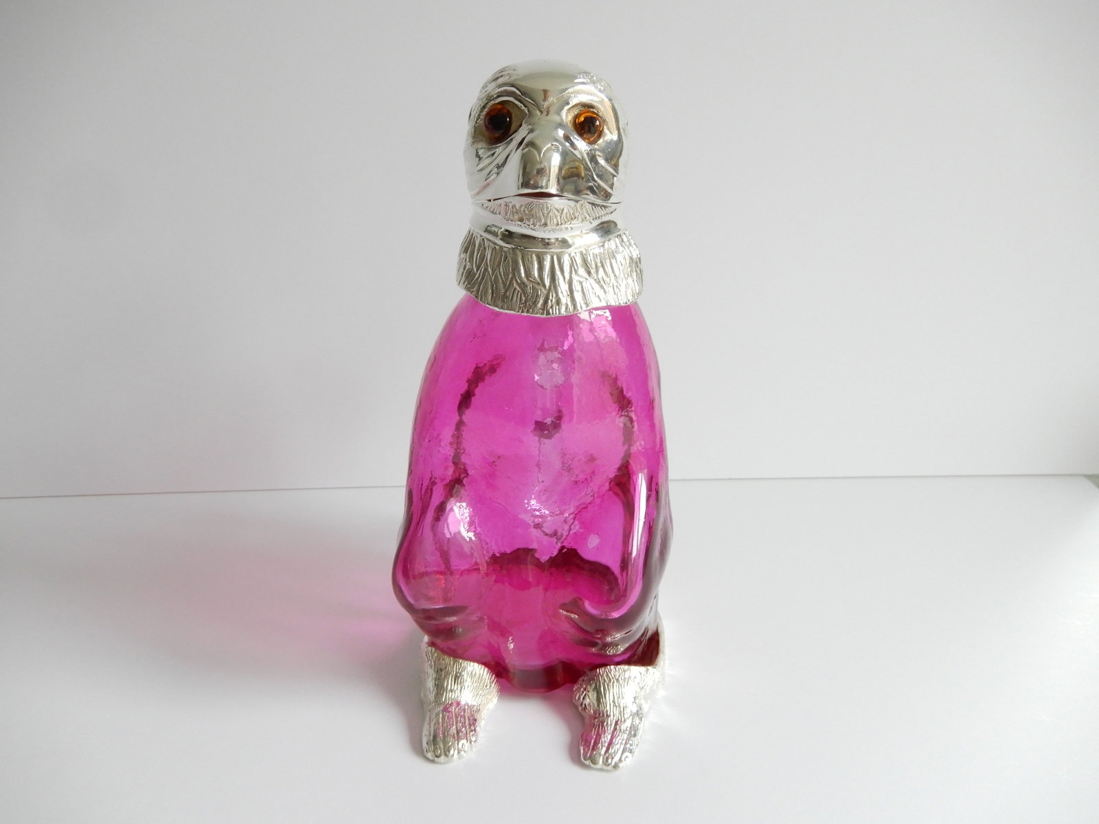 Victorian style French Pink Monkey Decanter: Victorian style French Pink Monkey Decanter. The glass body of the Monkey is a stunning pinkish color. The Monkey has a silverplated head with glass eyes. The silverplate is stamped on the back of the