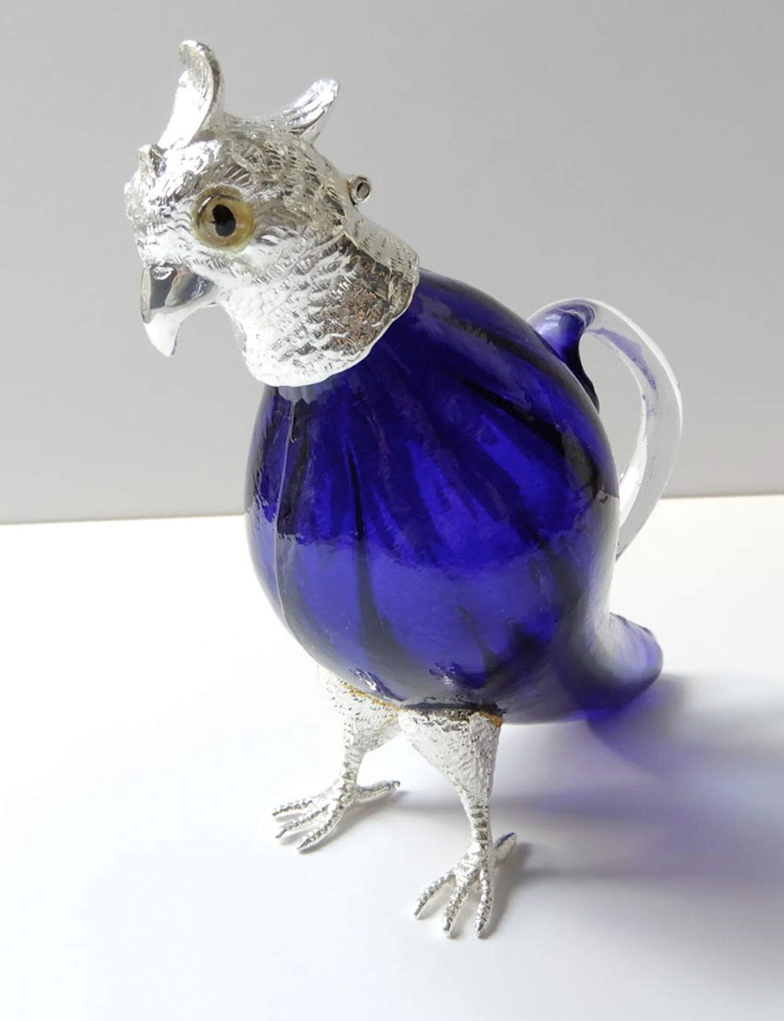 Victorian style French Blue Parakeet Jug Decanter.: Victorian style French Blue Parakeet Jug Decanter. The glass body of the parakeet is a stunning blue color. The parakeet has a silverplated head with glass eyes. The silverplate is stamped on the back