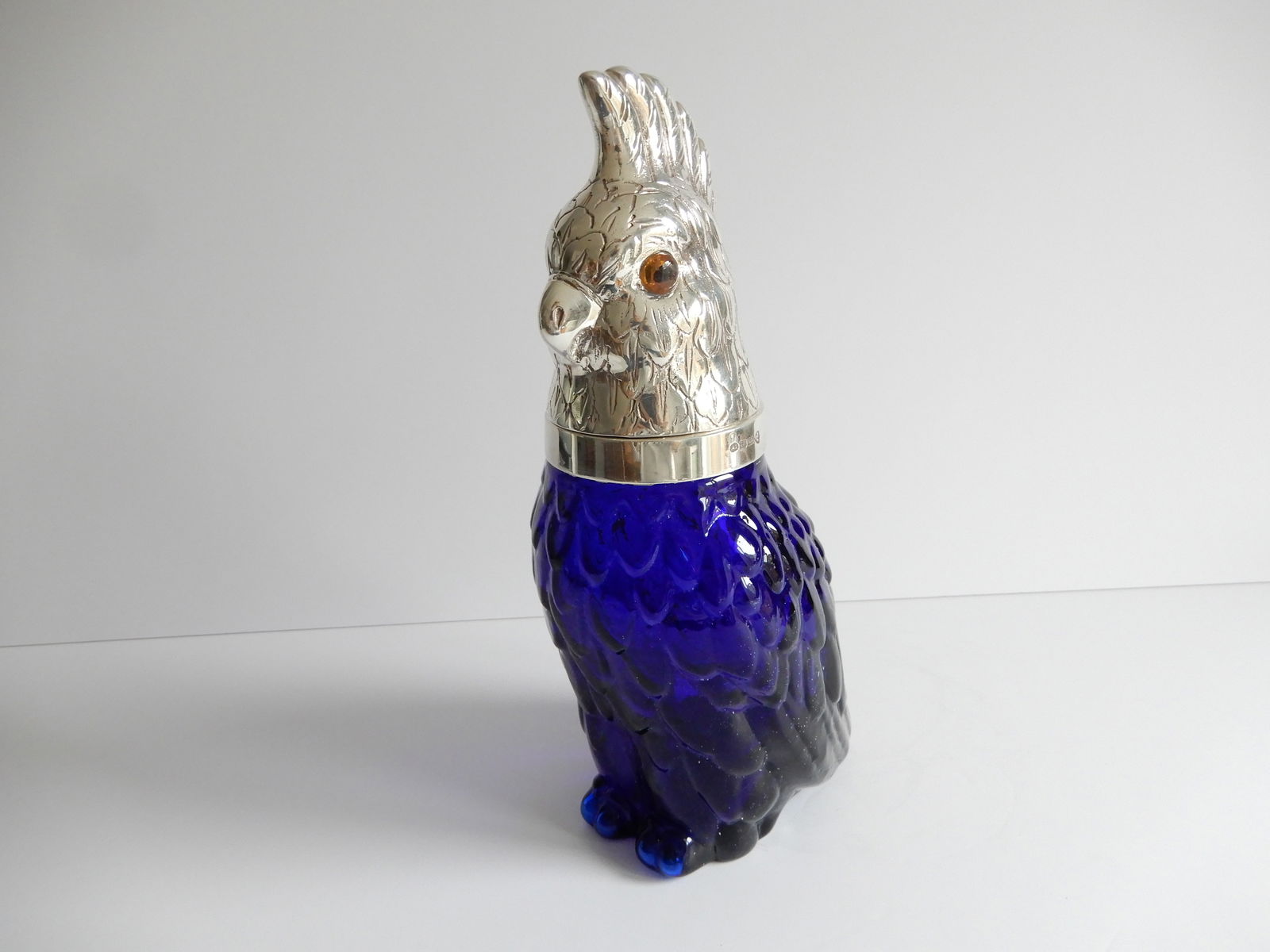 Victorian style French Blue Parrot Glass and Silver Decanter: Victorian style French Blue Parrot Glass and Silver Decanter. The glass body of the Parrot is a stunning Blue color. The Parrot has a silverplated head with glass eyes. The silverplate is stamped on t