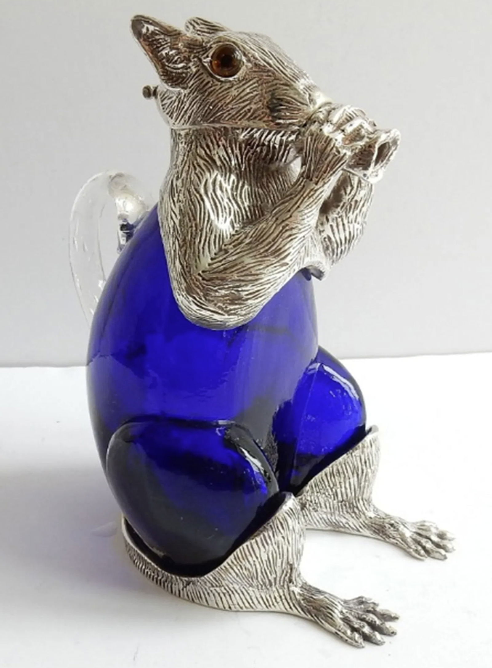 Victorian style French Blue Squirrel Decanter.: Victorian style French Blue Squirrel Decanter. The glass body of the Squirrel is a stunning pinkish color. The Squirrel has a silverplated head with glass eyes. The silverplate is stamped on the back