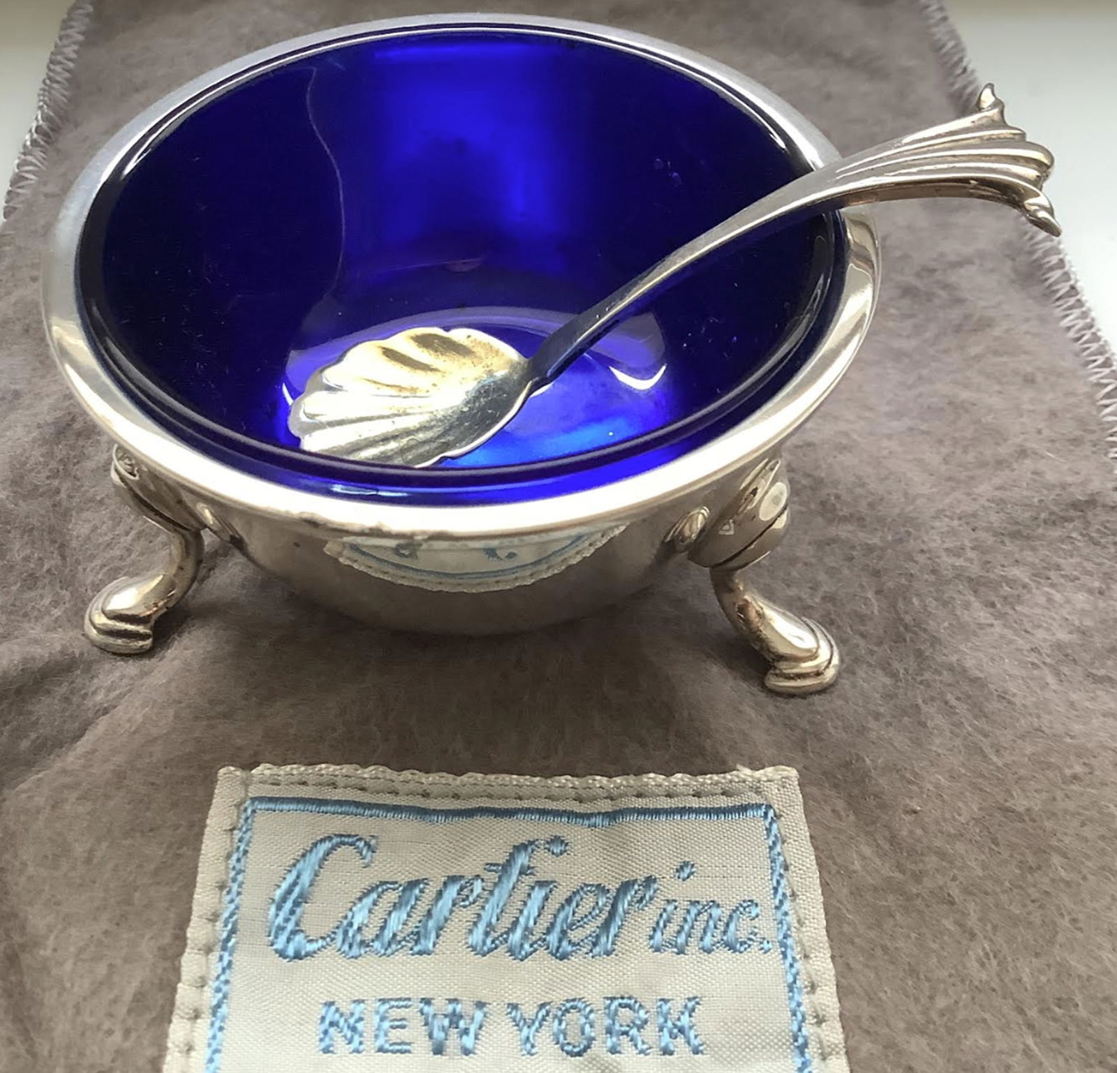 CARTIER STERLING SILVER LEAF TRINKET DISH BOWL AND ORIGINAL POUCH: CARTIER STERLING SILVER & COBALT FOOTED OPEN SALT CELLAR WITH SPOON AND ORIGINAL POUCH. Measures approx 2-1/4” ACROSS AND 1-1-4” TALL Great Condtion
