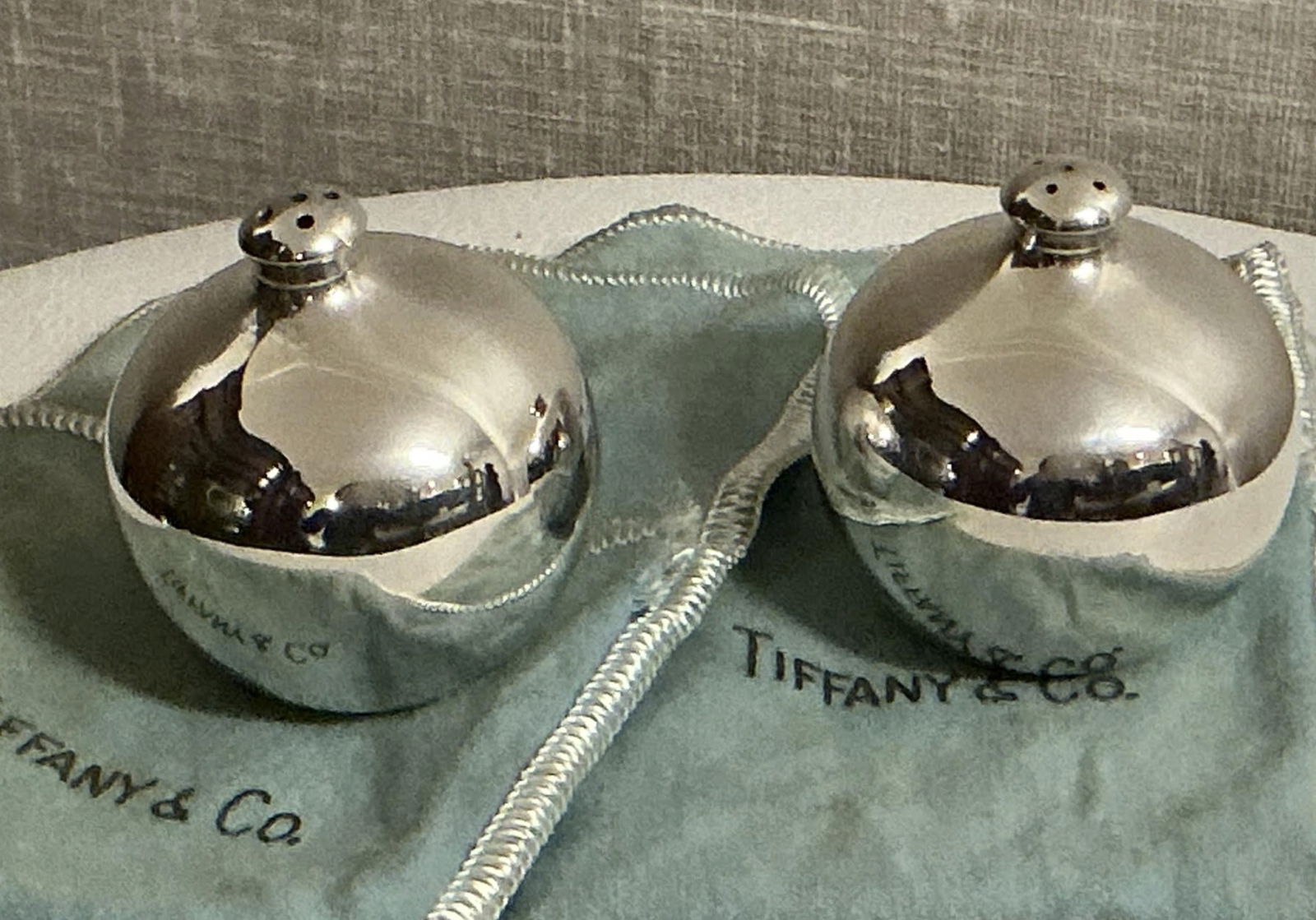 Tiffany & Co Sterling Silve Salt & Pepper Shakers With Orig Pouch: Tiffany & Co Sterling Silve Salt & Pepper Shakers With Orig Pouch. Measures approx They are 1 3/4" across by 1 7/8". Signs on bag wear