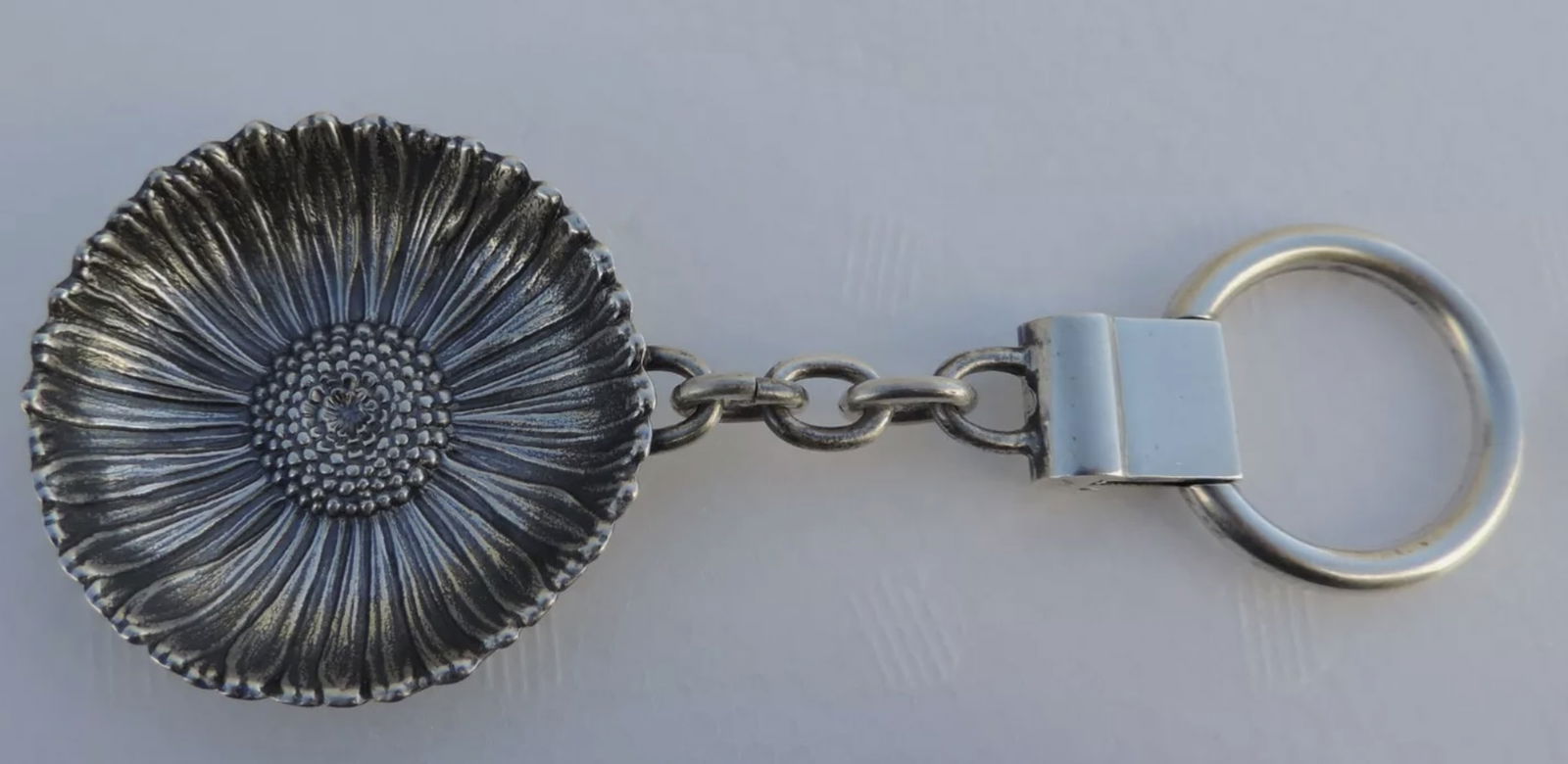 Buccellati Sterling Daisy Dish Key Chain Made In Italy: Buccellati Sterling Daisy Dish Key Chain Made In Italy SIZE: DAISY DISH IS APPROXIMATELY 1 3/4" WIDE TOTAL LENGTH 4 1/2". WEIGHT: 41 GRAMS.CONDITION: EXCELLENT VINTAGE CONDITION WITH ONLY MINOR AGE WE