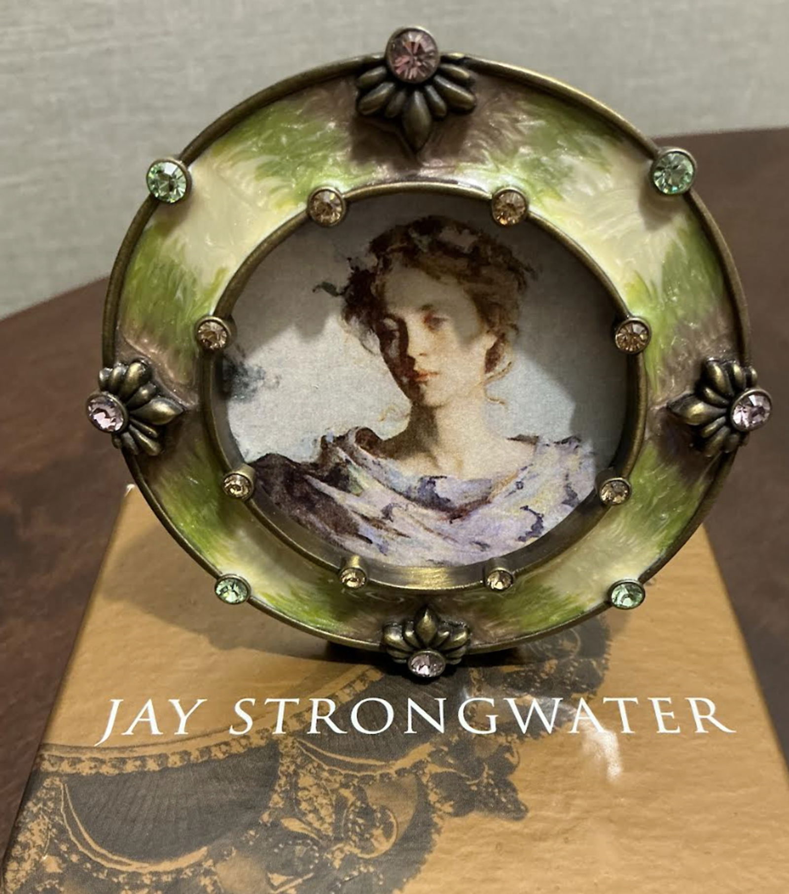 Jay Strongwater Enameled Round Jeweled Picture Frame with Original Box: Jay Strongwater Enameled Round Jeweled Picture Frame with Original Box. This piece is in good used condition with no major flaws and includes the original box. The plastic picture cover has a couple