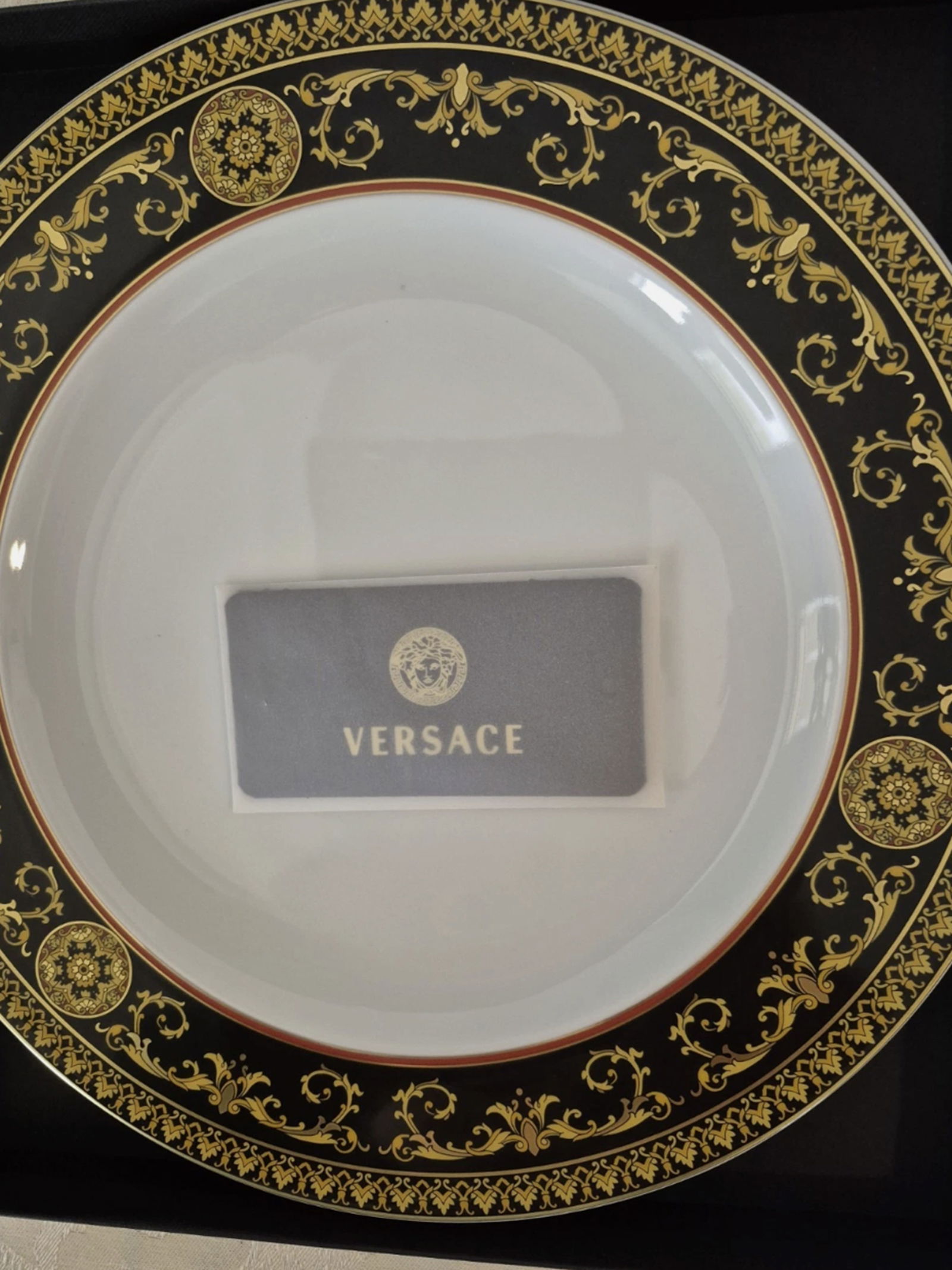 Versace Medusa 27' Plate New In Box with Certificate of Authenticity: The Versace Medusa 27' Plate is a decorative collector's item made of porcelain, featuring a round shape and a decorative style. Produced with an art pottery technique in the 2020s, this plate comes