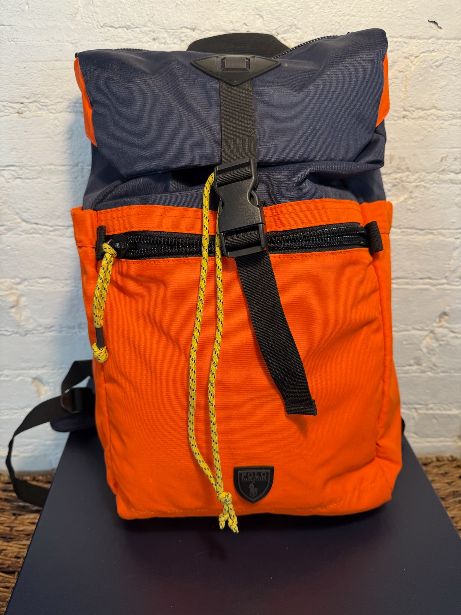 Polo Nylon Backpack: Polo Nylon Backpack Ample storage with extra pockets on sides, front, closure flap, and interior. Adjustable drawstring and clip closure. Padded straps. Lightly used, like new. Navy and Bright Orange