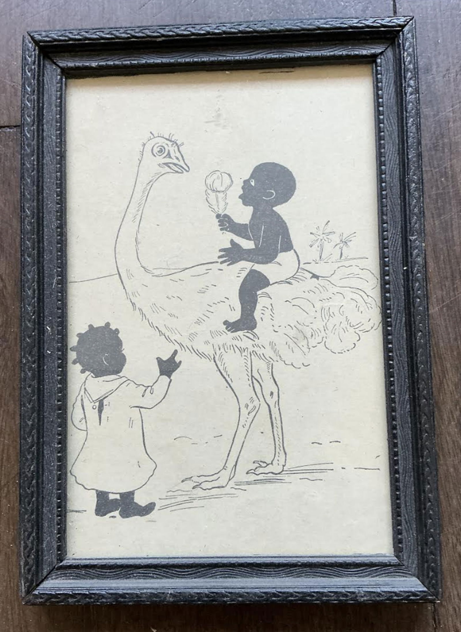 Black Americana Era Framed Art A black and white line drawing depicting a child riding an ostrich: Black Americana Era Framed Art A black and white line drawing depicting a child riding an ostrich while holding a feather duster, with another child looking on. Measures approx 4 3/4 inches 7 inches