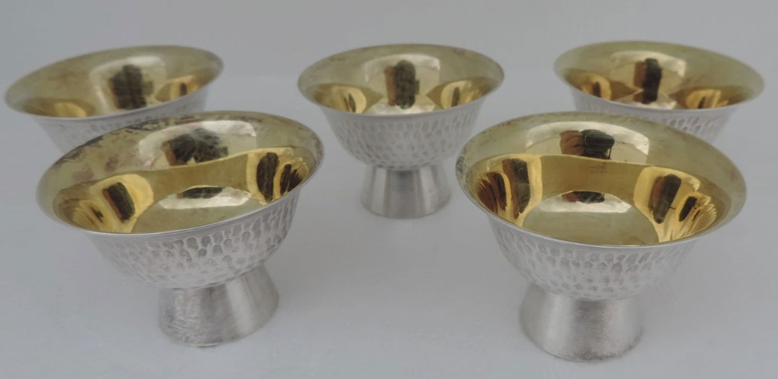 Japanese Sterling Silver Hamered Gold Wash Sake Cups In original Wooden Box: Japanese Sterling Silver Hamered Gold Wash Sake Cups In original Wooden Box.JAPANESE STERLING SILVER JAPANESE SAKE CUP WITH MASTERLY HAND HAMMERED EXTERIOR AND GOLD WASH INTERIOR, ALL CUPS ARE STAMPED