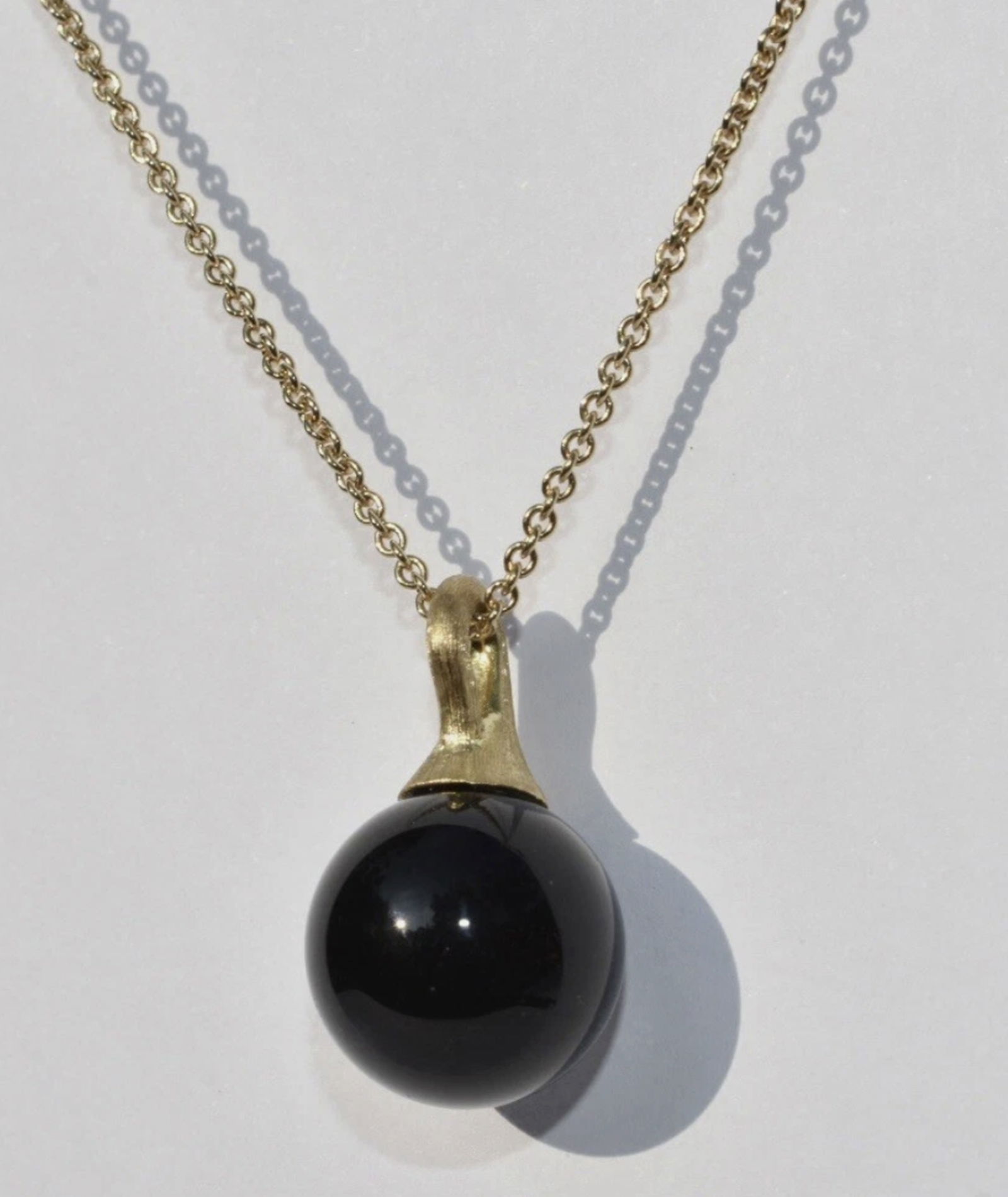 Marco Bicego Africa Boule Onyx Pendant Necklace 18K: Marco Bicego Africa Boule Onyx Pendant Necklace 18K. A Marco Bicego 'Africa' collection necklace set in 18k yellow gold. The necklace features a onyx boule pendant set to a fine gold chain with a