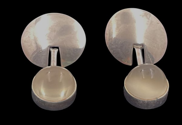 Pair of Sterling Silver & Moonstone Earrings in Mid-Century Modern Style: Pair of sterling silver and moonstone earrings in Mid-Century Modern style, with an elegant, geometric design. They measure 1 3/8'' by 7/8'' and bears hallmarks as shown.