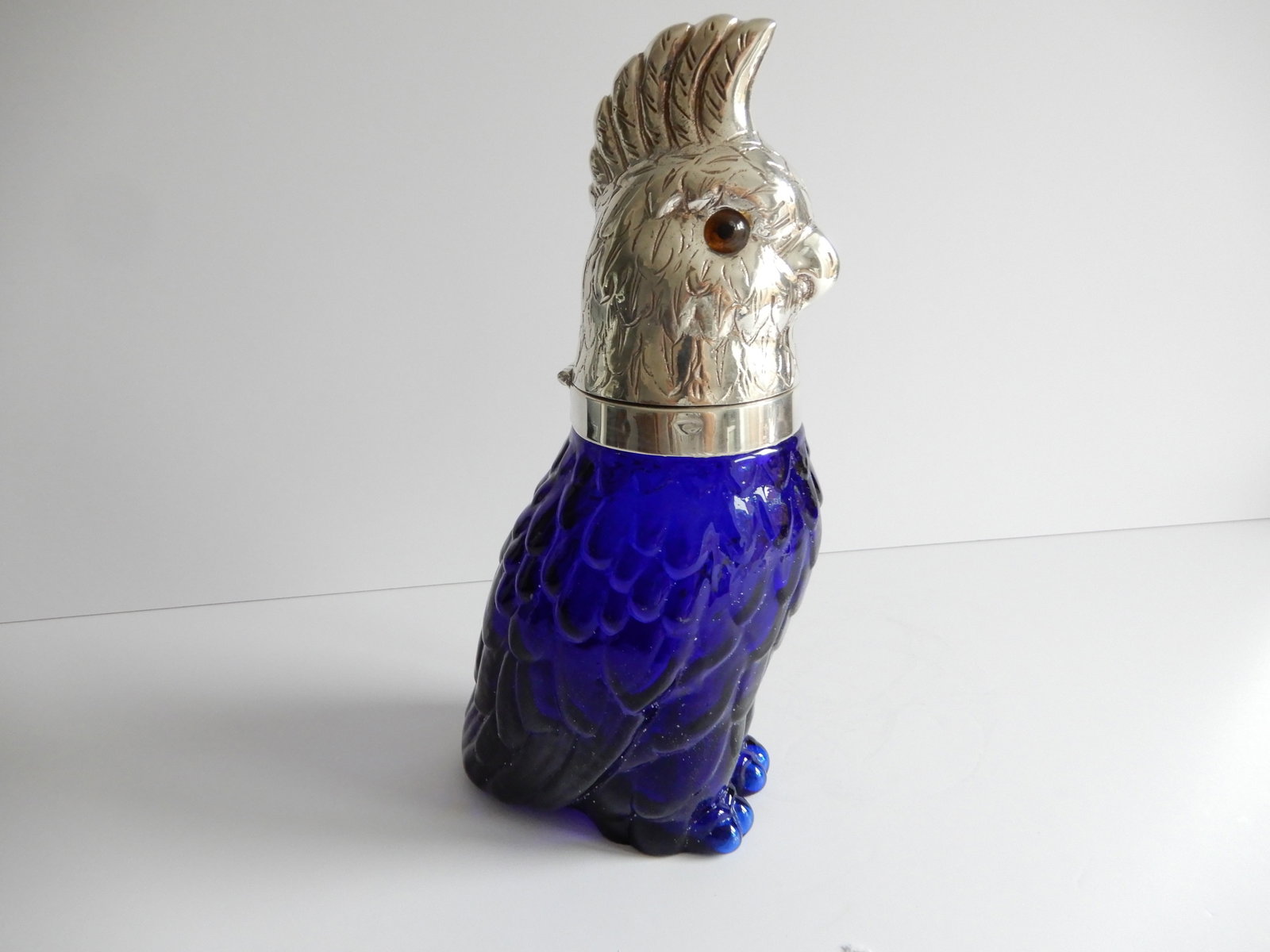 Victorian style French Blue Parrot Glass and Silver Decanter: Victorian style French Blue Parrot Glass and Silver Decanter. The glass body of the Parrot is a stunning Blue color. The Parrot has a silverplated head with glass eyes. The silverplate is stamped on t