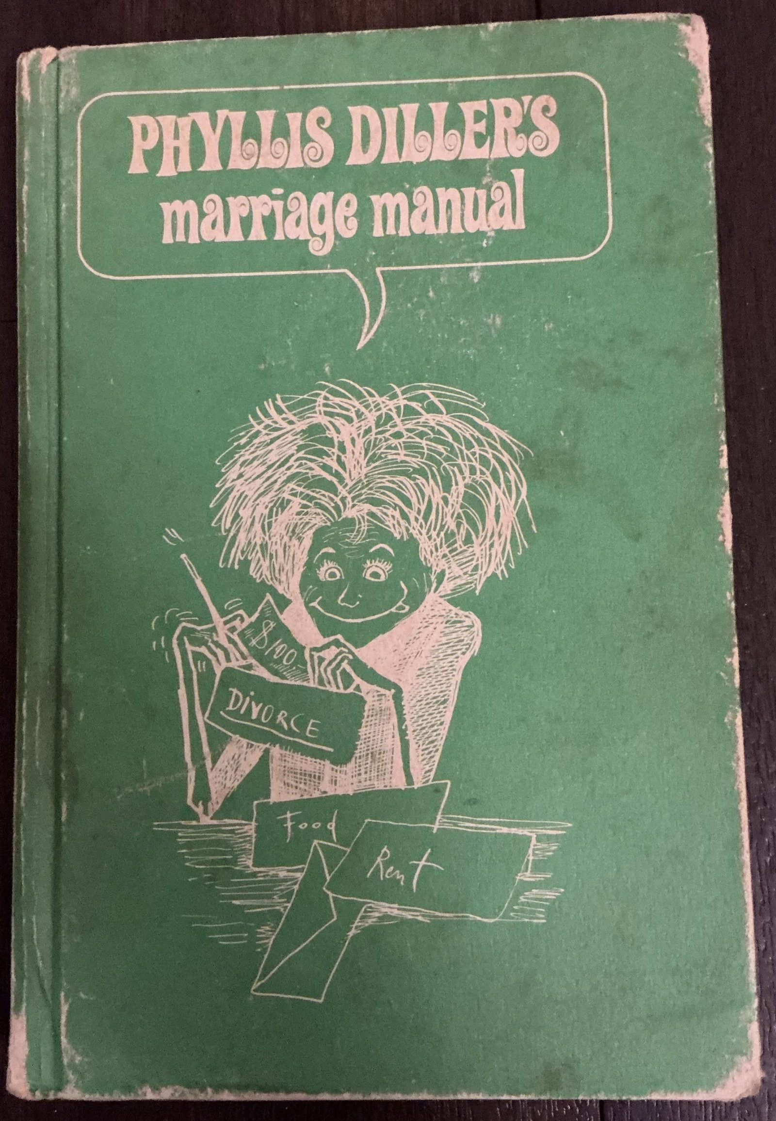 Phyllis Diller’s Marriage Manual Hard Cover Book 1967: Phyllis Diller’s Marriage Manual Hard Cover Book 1967 showcasing the legendary comedian’s unmistakable brand of self-deprecating wit and satirical domestic humor. The bold green cover with