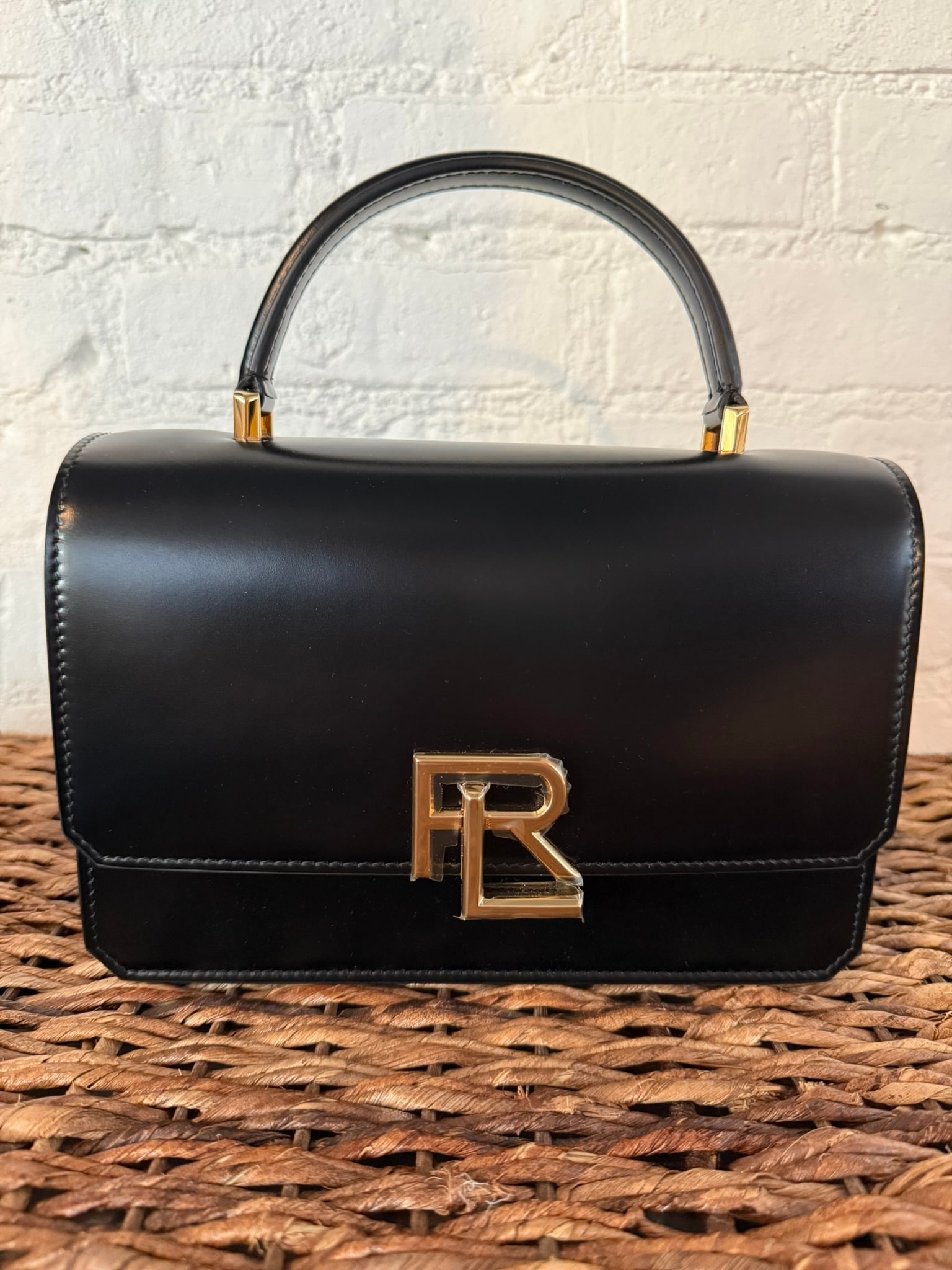 Ralph Lauren Collection Stacked RL Top Handle Bag: Black Ralph Lauren Collection Stacked RL Top Handle Bag Black leather construction. Includes detachable/adjustable crossbody strap. External back pocket and internal pocket. Locking mechanism in RL