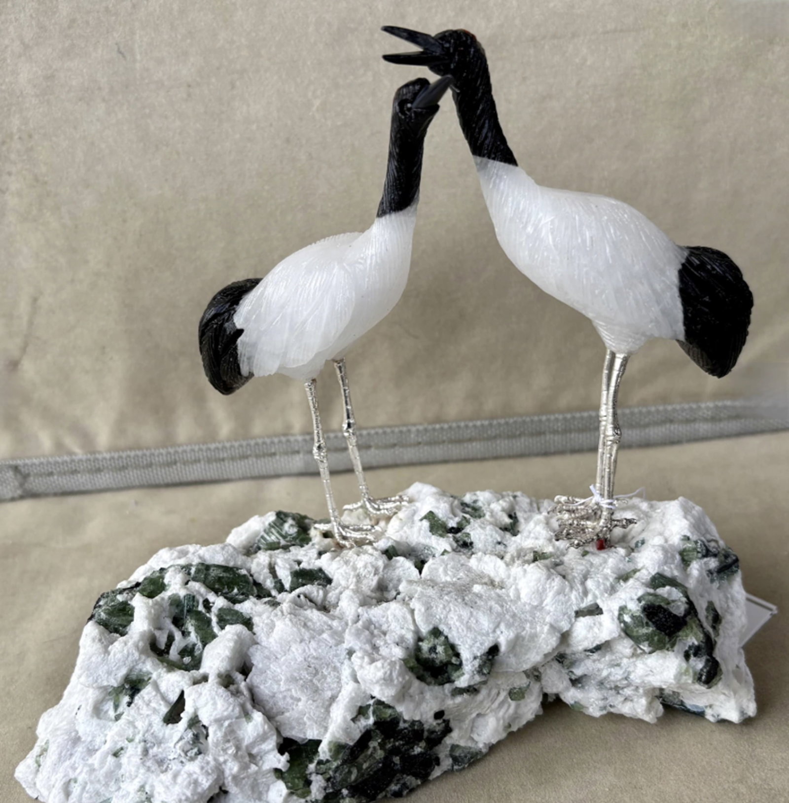 Japanese Crane Pair Figurine By Peter Muller Carved Sculpture Of Natural Gems: Japanese Crane Pair carved from White Quartz and Obsidian with Red Coral cap . The cranes stand on a base of Tourmaline crystals in Albite. Colors are totally natural to the stone. Measures approx 5" 