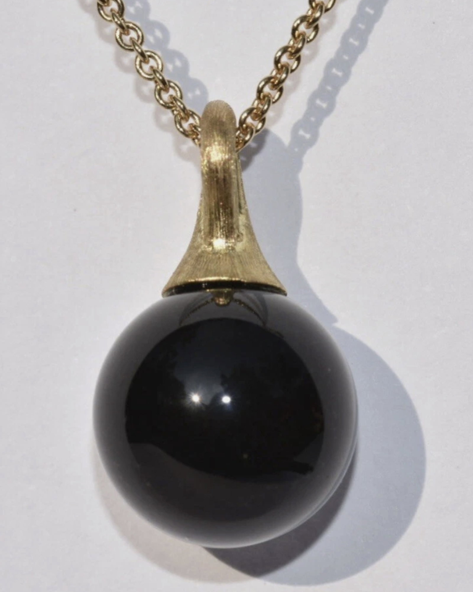 Marco Bicego Africa Boule Onyx Pendant Necklace 18K: Marco Bicego Africa Boule Onyx Pendant Necklace 18K. A Marco Bicego 'Africa' collection necklace set in 18k yellow gold. The necklace features a onyx boule pendant set to a fine gold chain with a lobs