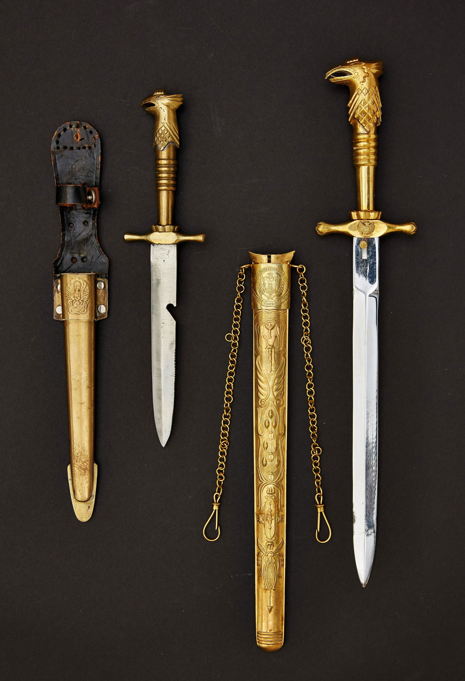 INDONESIEN - PrÃ¤sentationsdolch des Chefs der: Brass hilt with eagle head. Guard and scabbard with large Indonesian state emblem. Embossed brass scabbard with floral decoration. On suspension chain. Blank blade. In original presentation case. This