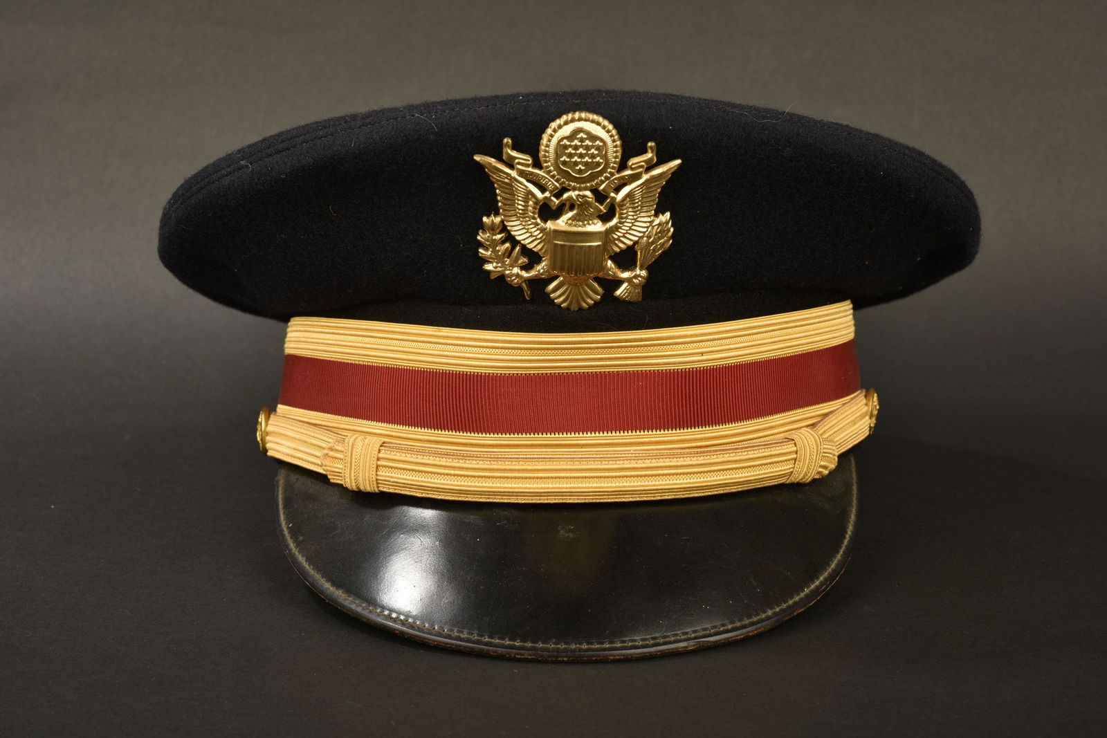 Modern US officer cap. Casquette officier US moderne: En drap noir, bandeau or et rouge. Fausse jugulaire prÃ©sente. Insigne d'officier en mÃ©tal dorÃ©. IntÃ©rieur doublÃ© en tissu impermÃ©able transparent. Fabrication Bancroft. Etiquette nom