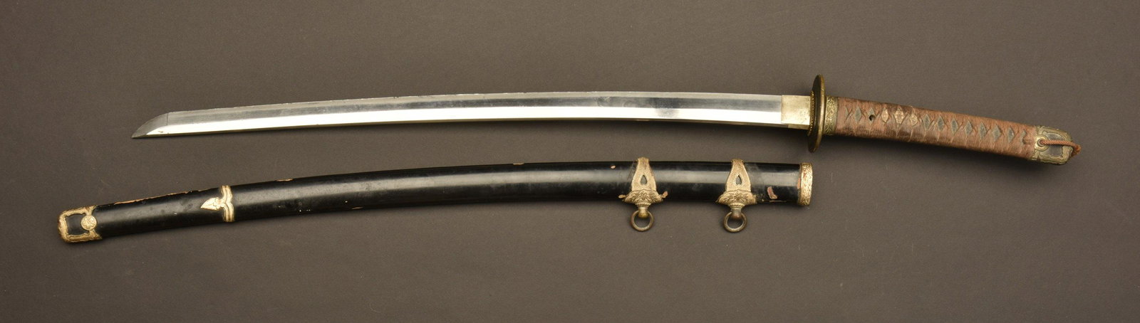 sabre marine japonaise. Japanese navy sabber: ModÃ¨le Kai Gunto 1937 type Tachi. PoignÃ©e disposant de dÃ©cors floraux sous le tressage d'origine. Tsuba en mÃ©tal prÃ©sentant un certain jeu. Lame dans sa longueur d'origine. Quelques mar