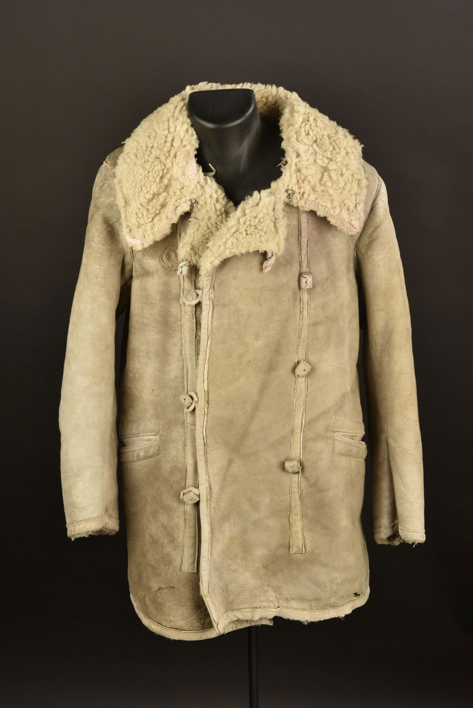 Manteau hivernal allemand. German winter coat.: En peau retournÃ©e, doublÃ© de fausse fourrure. Tous les boutons sont prÃ©sents. Une doublure de poche manquante. Tampon indiquant une taille III. A noter une certaine usure et patine de la piÃ