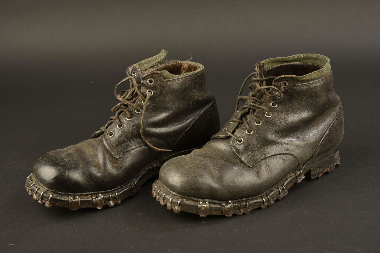 Brodequins de Gebirgsjager. Boots from Gebirgsjager: Paire homogÃ¨ne en cuir noir. Haut des chaussures disposant d'une bande en tissu Felgrau. Une bande est incomplÃ¨te et dÃ©chirÃ©e. Sept Å“illets de laÃ§age. Les lacets en cuir sont prÃ©