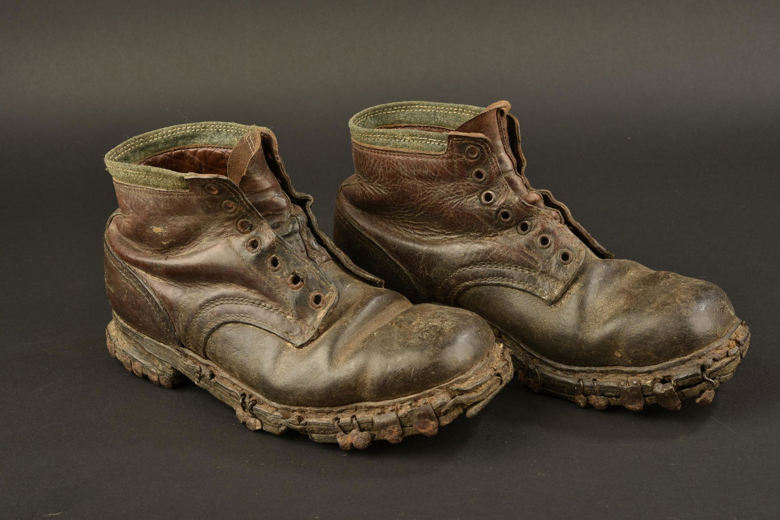 Brodequins de Gebirgsjager. Boots from Gebirgsjager: Paire homogÃ¨ne en cuir noir. Haut des chaussures disposant d'une bande en tissu Felgrau. Sept Å“illets de laÃ§age. Les lacets en cuir sont absents. Semelles ferrÃ©es et cloutÃ©es, fortemen