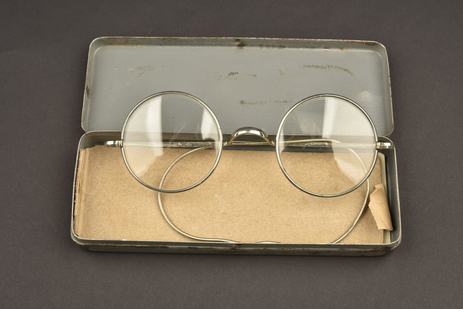 Paire de lunette regimentee. Pair of regimented: Premier modÃ¨le de boite en mÃ©tal, peinture grise Ã 80%. Marquages sur le couvercle Dienstbrille. Lunettes de vue complÃ¨tes, verre en trÃ¨s bon Ã©tat, armature en mÃ©tal, couleur arge