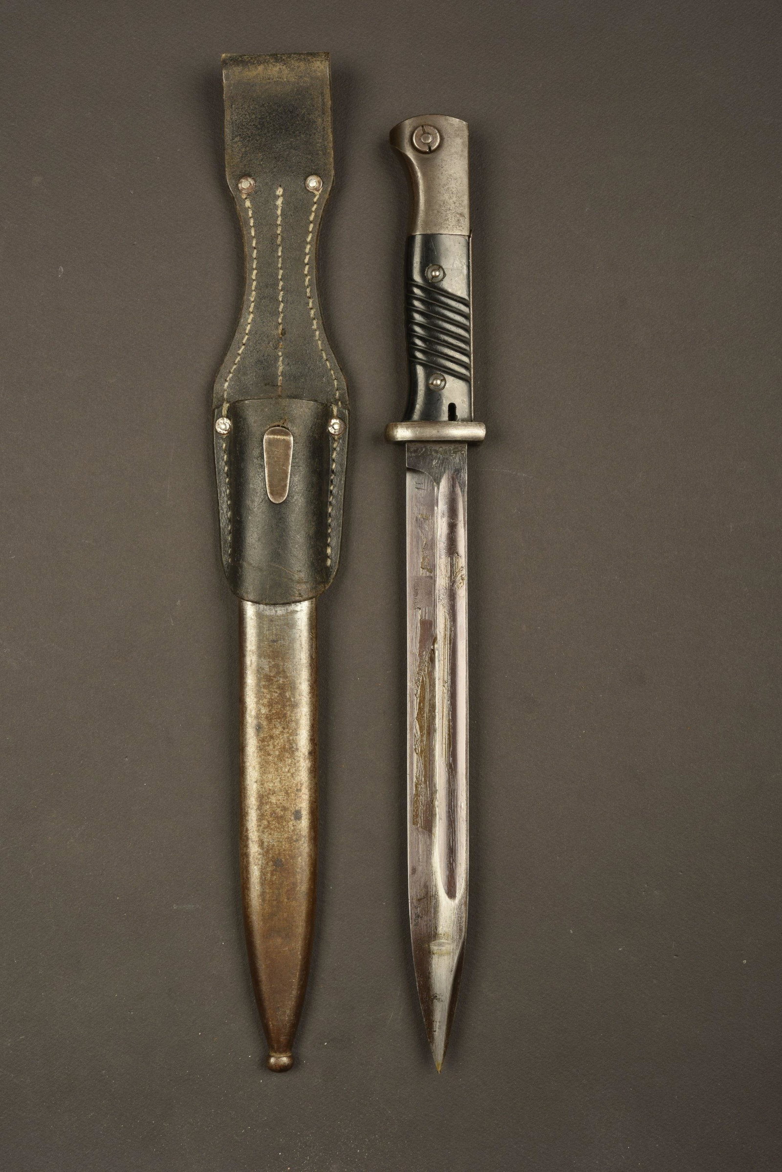 Baionnette 98K. 98K Bayonet: Plaquettes en bakÃ©lite, maintenues par deux rivets. Lame dans sa couleur d'origine Ã 80%, fabrication 42 ASW, numÃ©ro 2808l. Fourreau en mÃ©tal, couleur d'origine Ã 20%, numÃ©ro 2808l, 