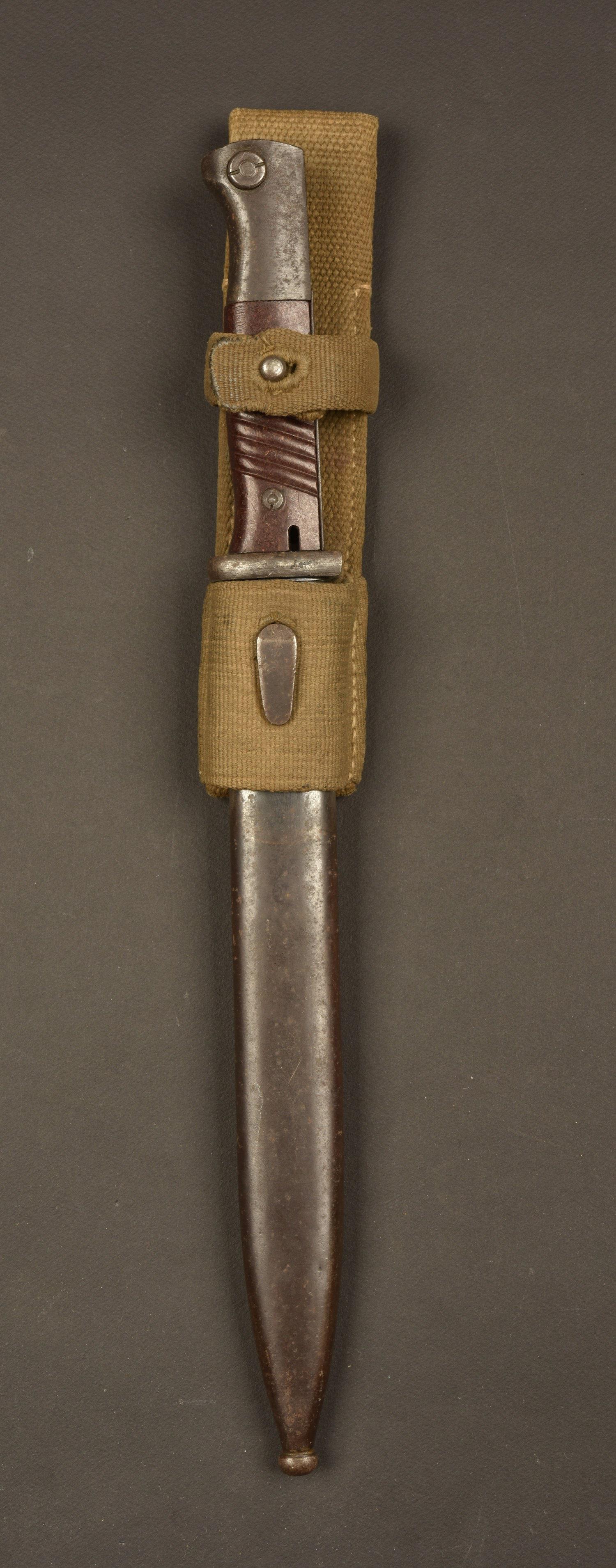 Baionnette 98K et gousset tropical. 98K bayonet and: Plaquettes en bakelite marron, maintenues par deux rivets. Lame complete, fabrication 44 ASW, numero 7301. Fourreau en mÃ©tal, couleur d'origine Ã 70%, numero 2365, arme pas au numero. fabricatio