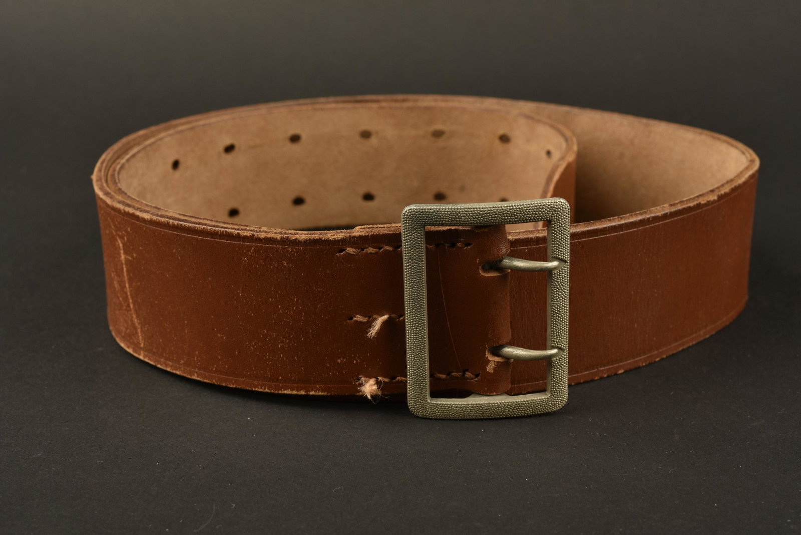Ceinturon officier allemand. German officer belt: En epais cuir fauve. Boucle en metal grenele a deux ardillons, sans marquages visibles. Fabrication Springer & Co Berlin. A noter une legere usure et patine de la piece. In thick tawny leather. Grai