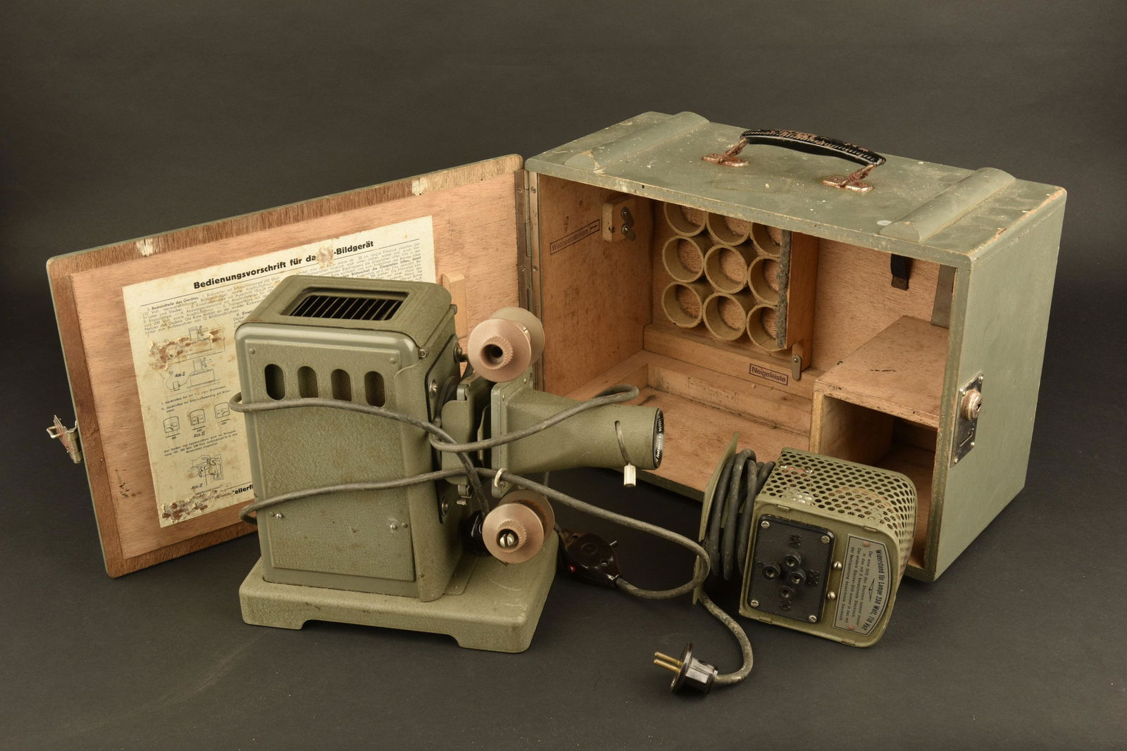 Projecteur de film allemand. German film projector.: Caisse en bois, peinture a 80%. Poigne de transport presente. Serrure fonctionnelle, cle manquante. Mode d'emploi present, quelques manques sur la feuille. Fabrication ED Liesegang Dusseldorf. Project