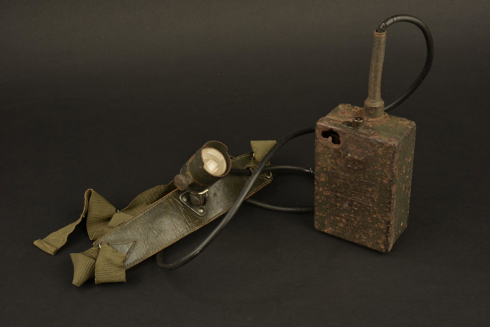 Lampe frontale. Headlamp.: Lampe en metal, ampoule presente, verre intact, tous les cables sont presents, mais denudes et repares avec du scotch. Armature en metal, et cuir. Tous les boutons pressions sont fonctionnels. Elastiq