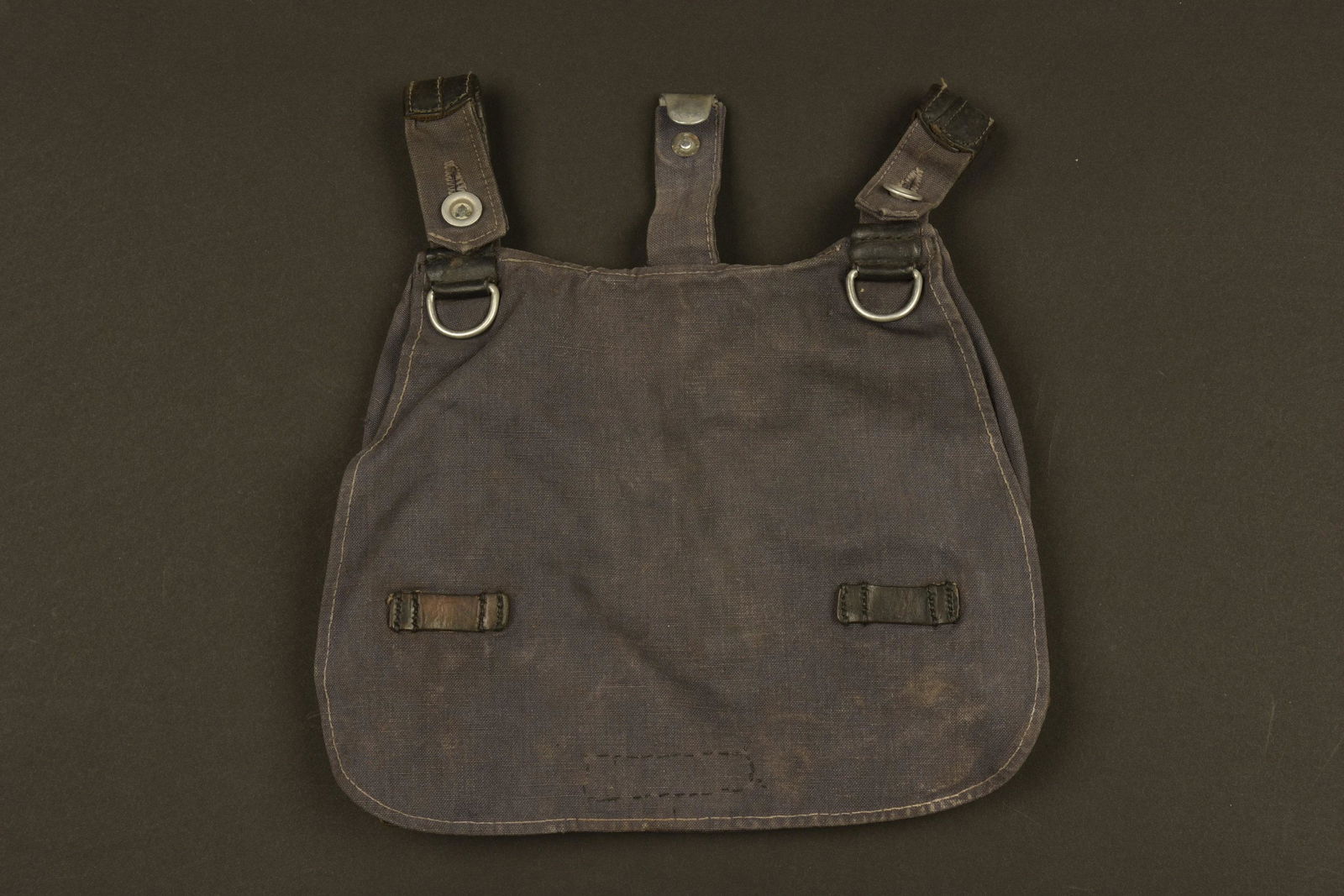 Sac a pain nominatif LW. Luftwaffe named bread bag: En tissu coton gris bleu et cuir noir. Sans marquages visibles. A noter une certaine patine de la piece, ainsi qu'un accroc sur la face avant. La sangle de transport est manquante. Marquages sous le r