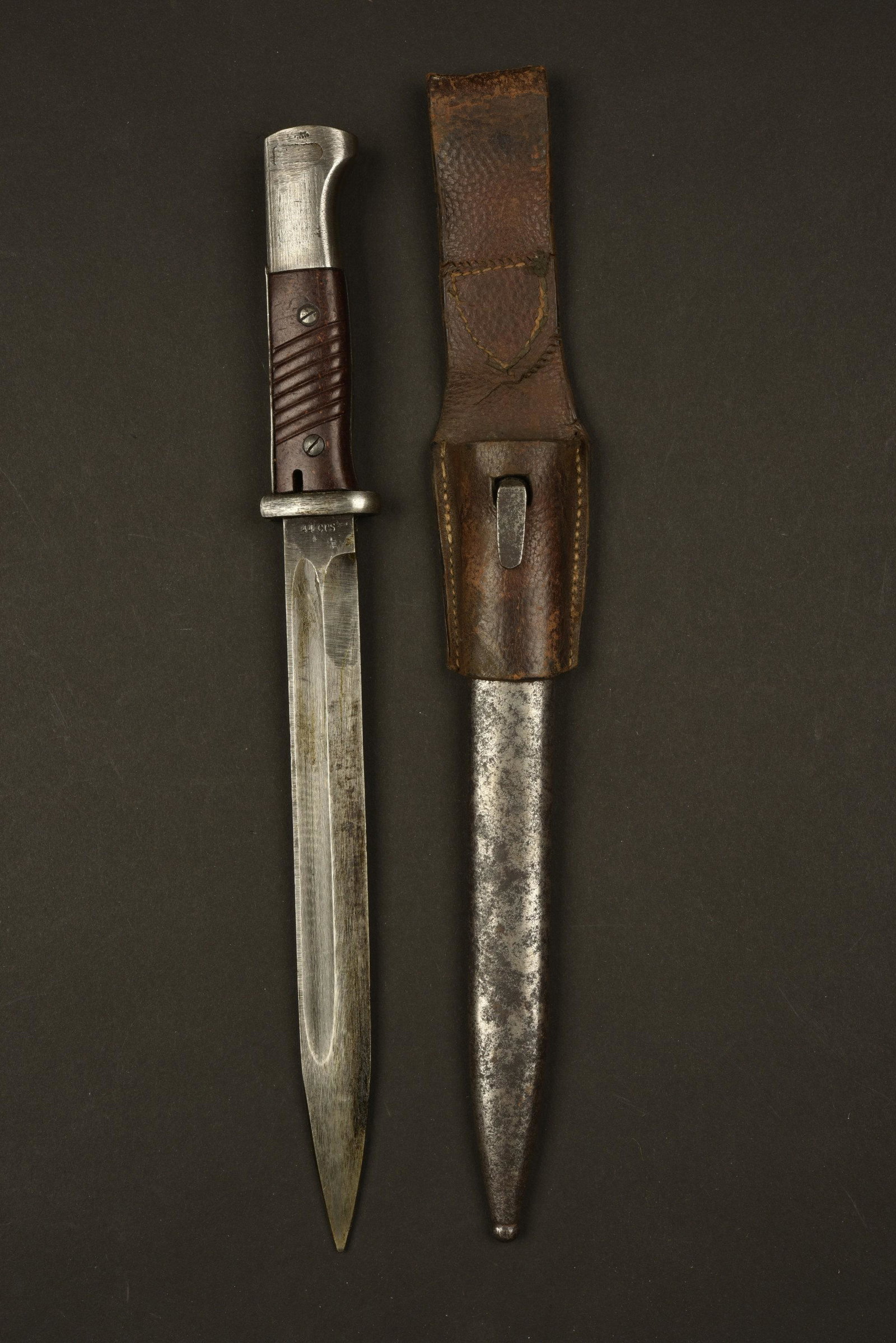 Baionnette 98K. 98K Bayonet.: Plaquettes en bakelite, maintenues par deux rivets. Lame dans sa couleur d'origine a 80%, fabrication 44 CRS, numero 2671h. Fourreau en metal, sans peinture et oxyde, sans marquages visible. Gousset
