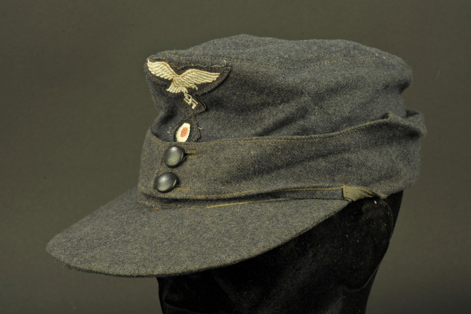 Casquette M-43 de la Luftwaffe. Luftwaffe M-43 cap.: En drap gris/bleu. Deux boutons type civil fermant le rabat. Aigle de la Luftwaffe du second type monte machine. Cocarde brodÃ©e montee machine. Interieur double en satinette bleu, bandeau de transp