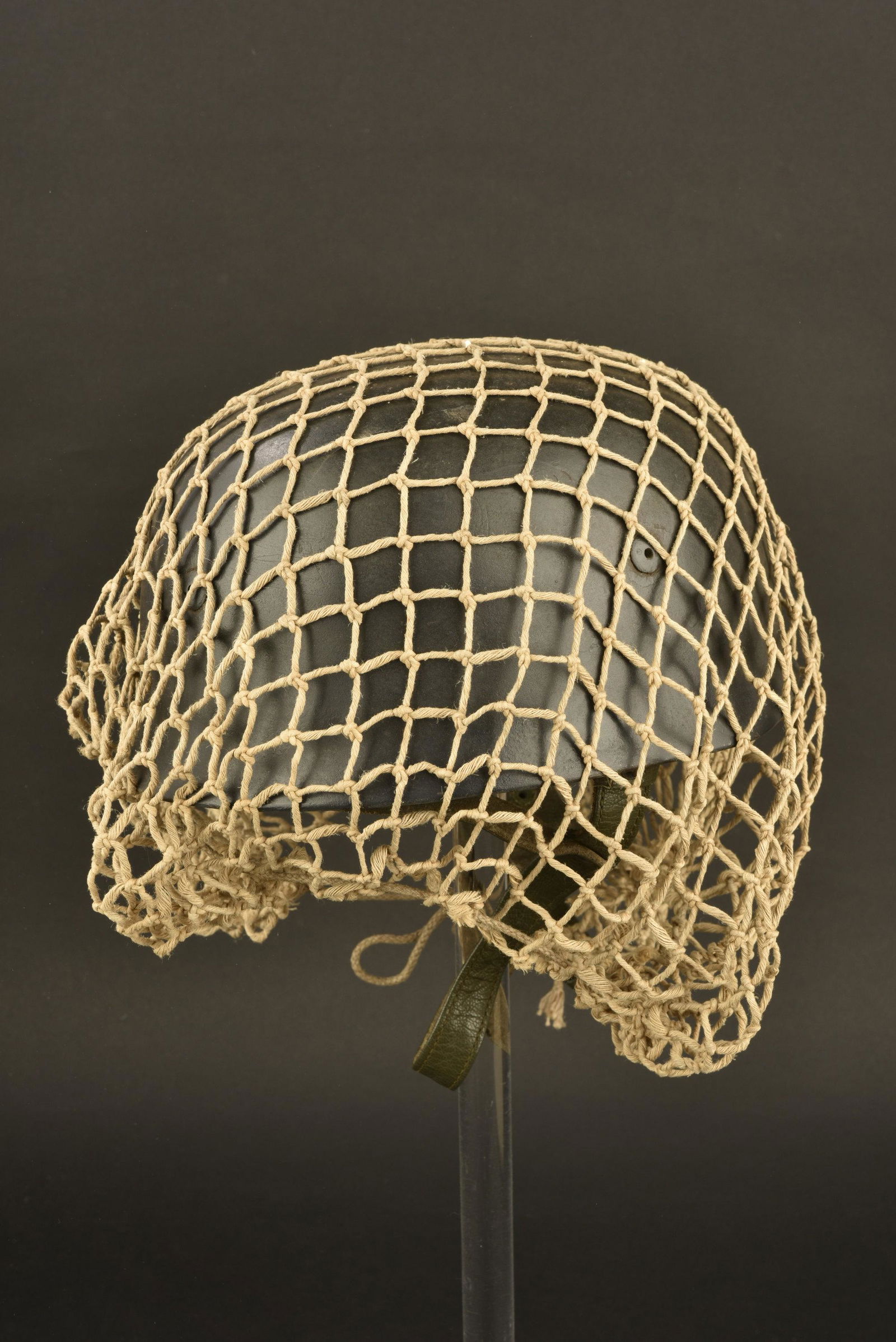 Casque de parachutiste. German paratrooper helmet: Coque de casque M38, fabrication ET 68, repeinte. Coiffe et jugulaire reproduction. Filet de camouflage present mais d'un modele moderne. Trace d'un aigle de la Luftwaffe du second type. A noter une c