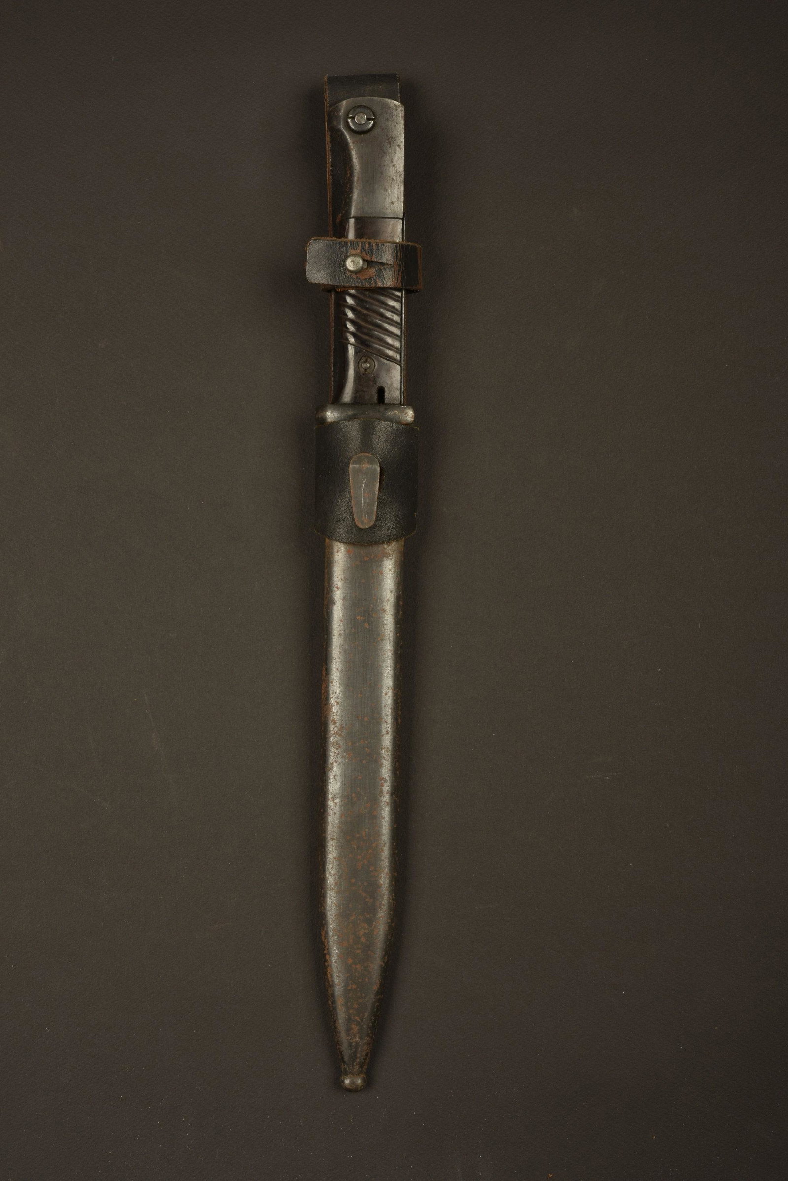 Baionnette de Mauser 98K. 98K Bayonet.: Plaquettes en bakelite, maintenues par deux rivets. Lame dans sa couleur d'origine Ã 98%, fabrication JWH, numero 278f. Fourreau en metal, peinture Ã 60% et oxyde, sans marquages visible. Gousse